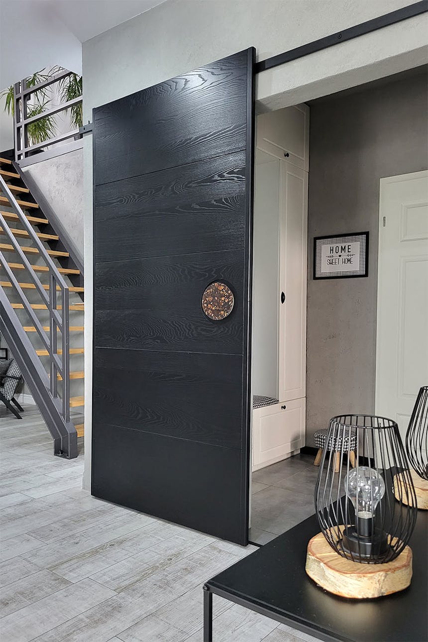 Minimalistische schwarze Schiebetür mit Designergriff in der Halle eines modernen Hauses