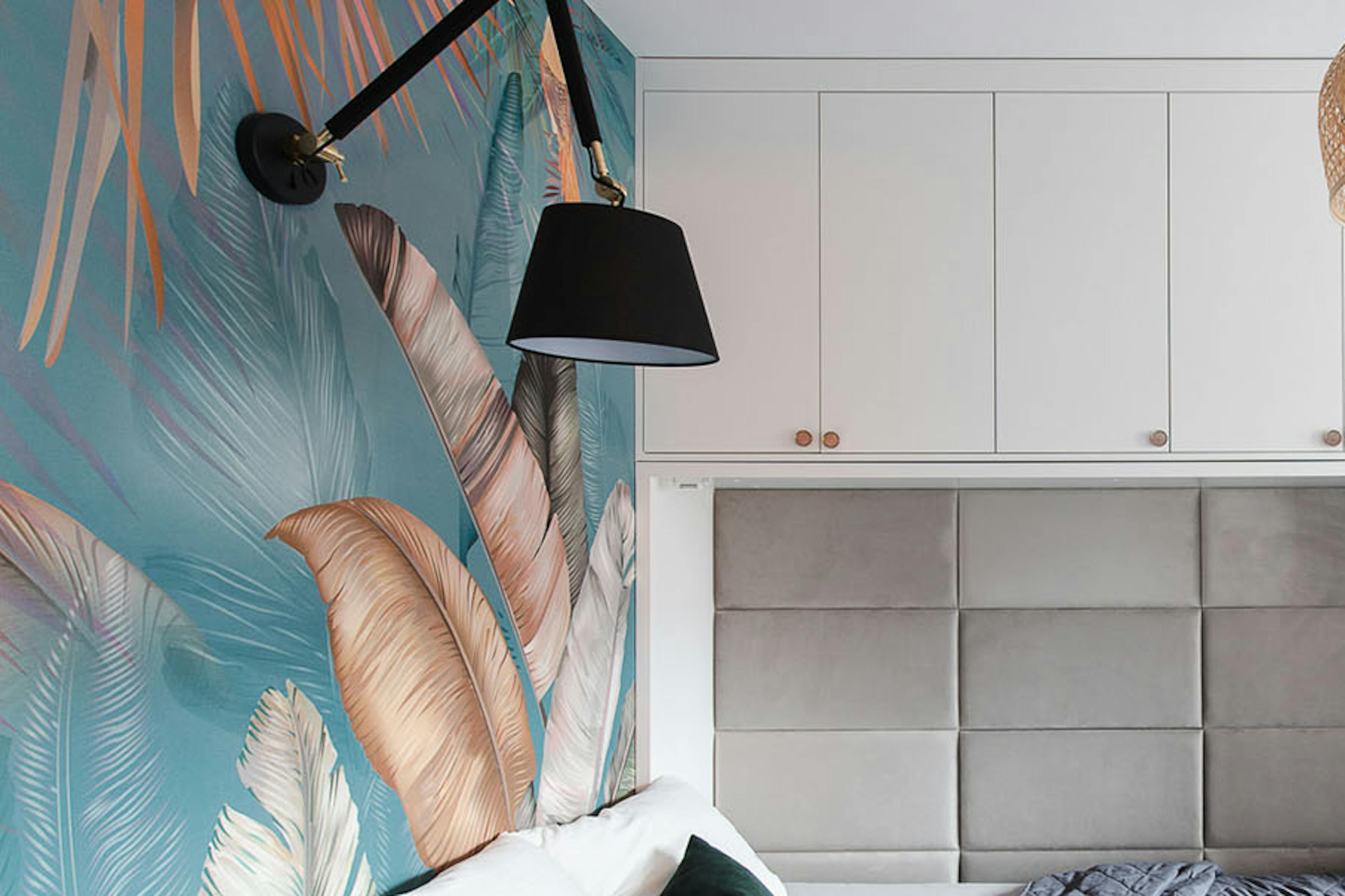 un lit caché dans l'armoire et du papier peint coloré au mur dans une petite chambre