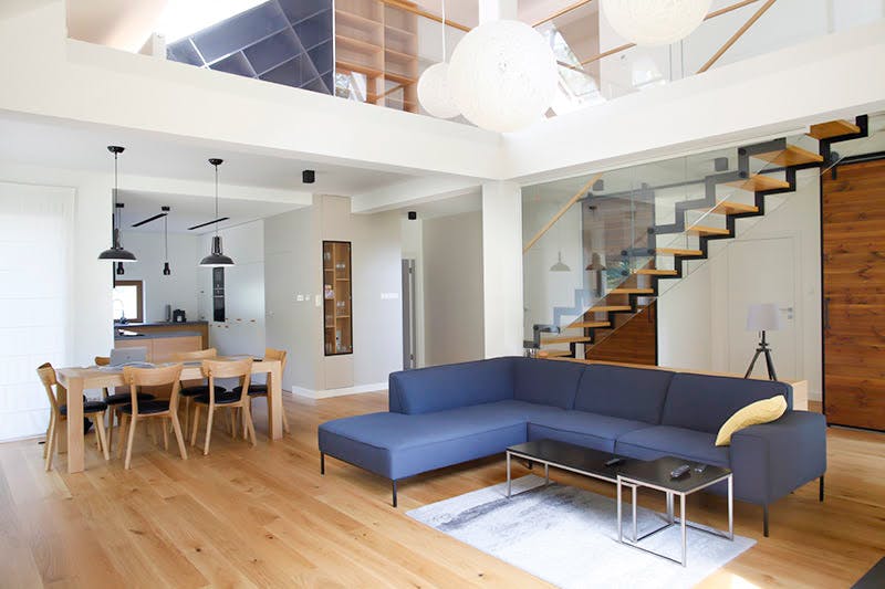 grand canapé bleu dans un salon décloisonné dans une maison moderne