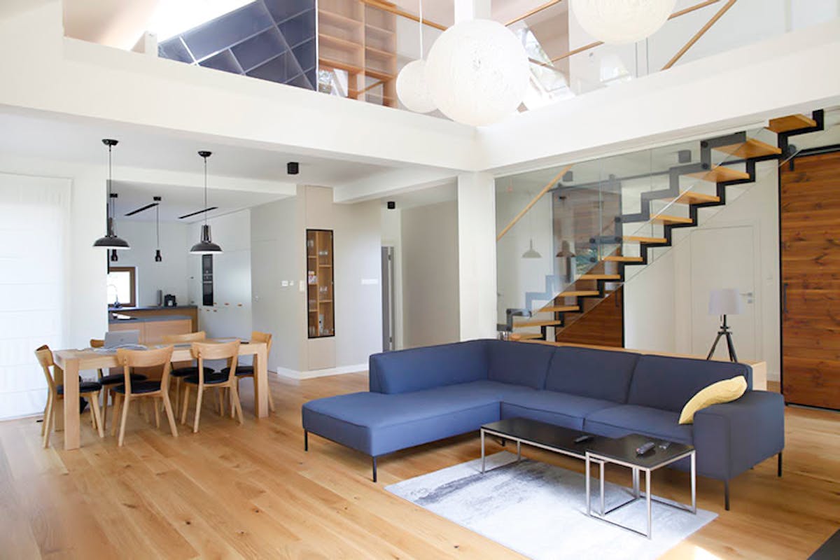 duża niebieska sofa w salonie na otwartym planie w nowoczesnym domu
