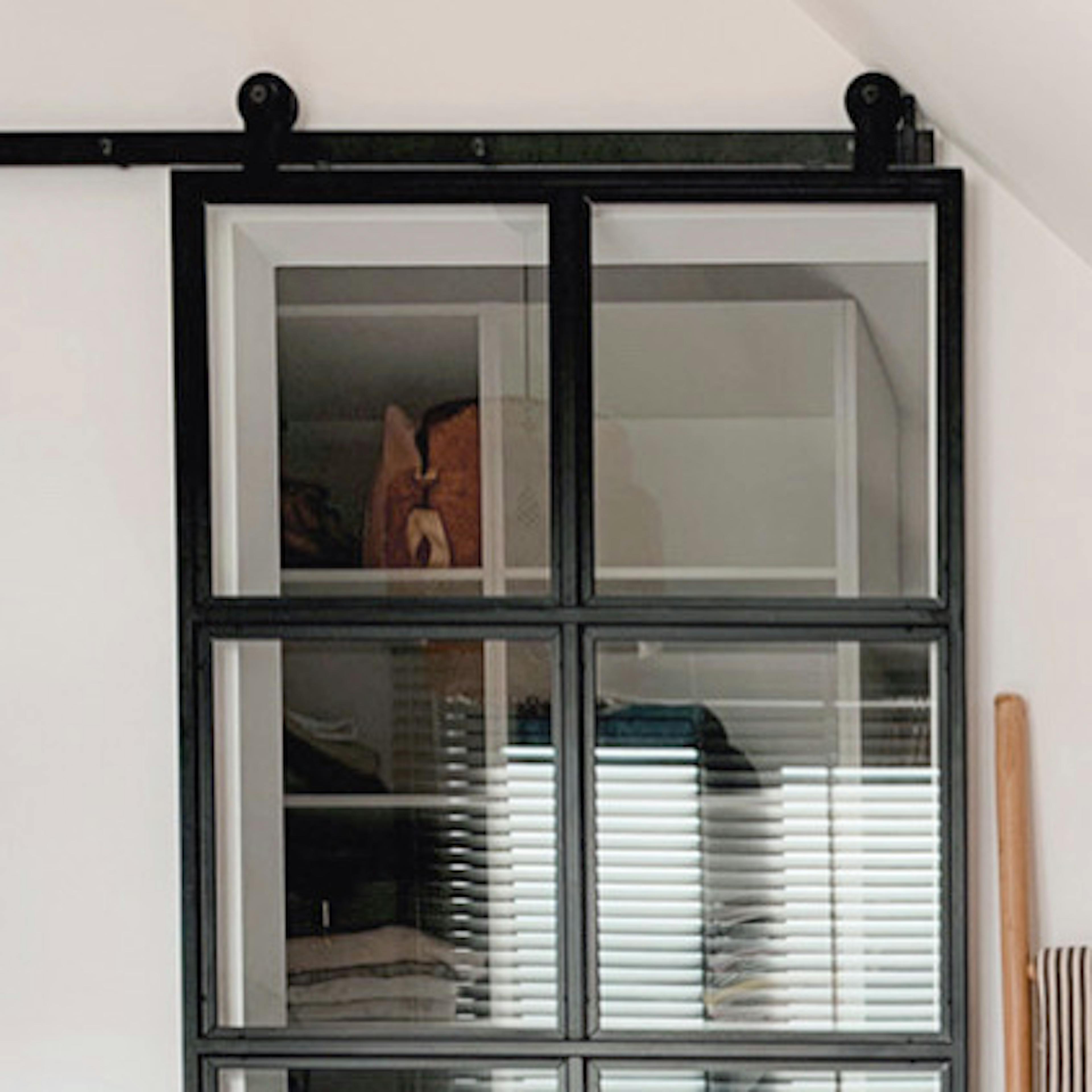 chambre mansardée avec une petite dressing cachée derrière des portes coulissantes en verre