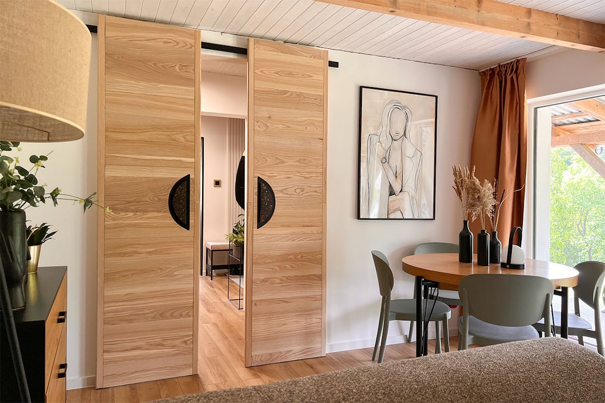 designerskie drzwi przesuwne w aranżacji pokoju gościnnego utrzymanego w naturalnej kolorystyce