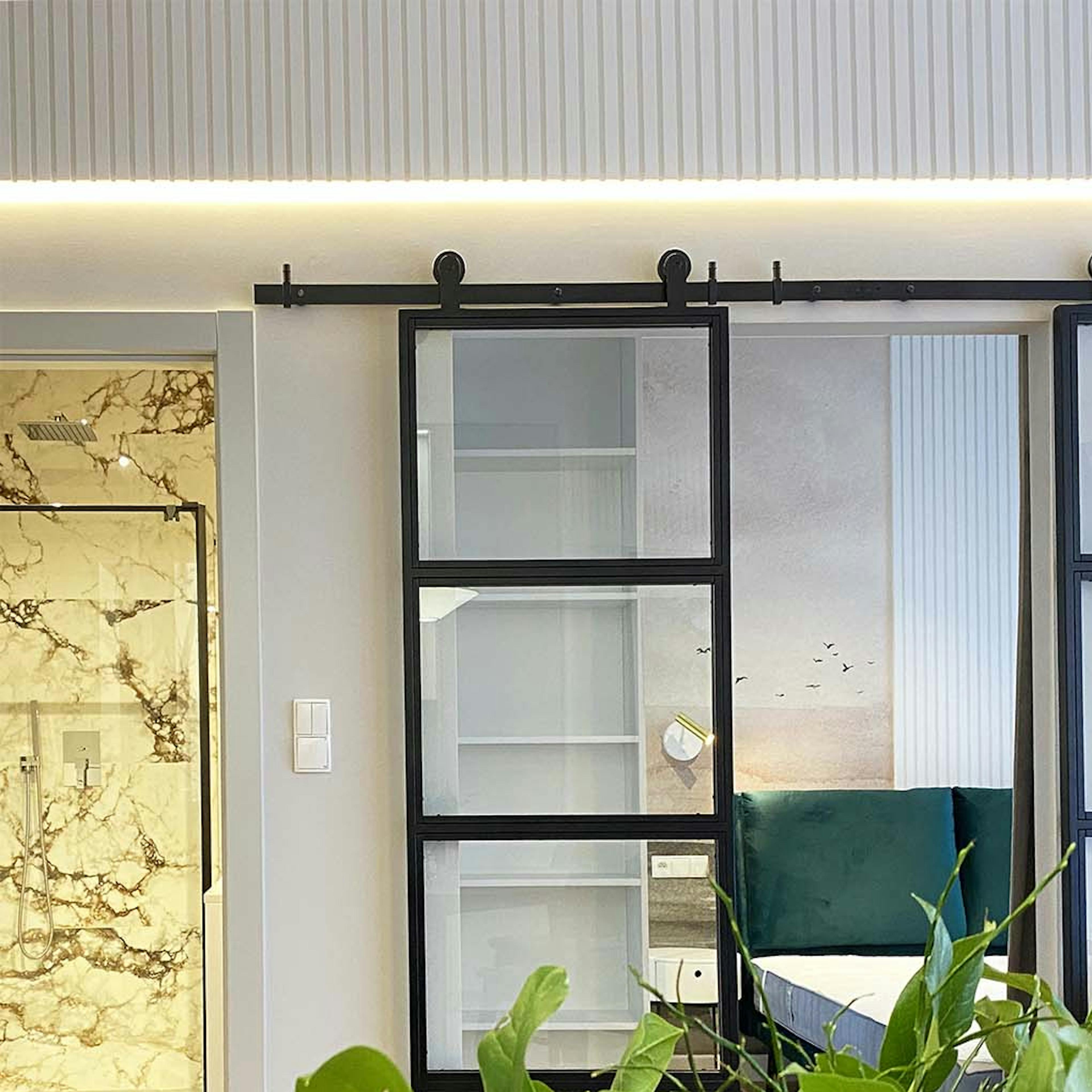 portes coulissantes en verre double séparant le salon de la chambre dans un appartement moderne