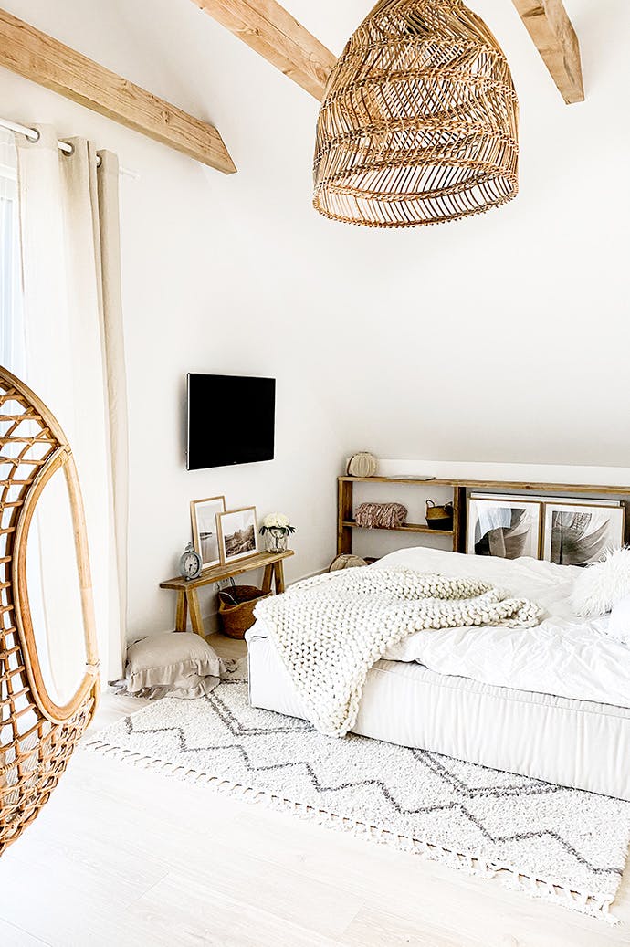 grand lit dans une chambre de style rustique avec du bois blanc et naturel