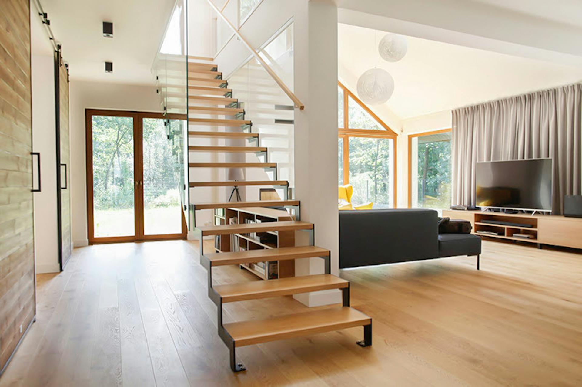 durchbrochene Holztreppe im geräumigen Wohnzimmer