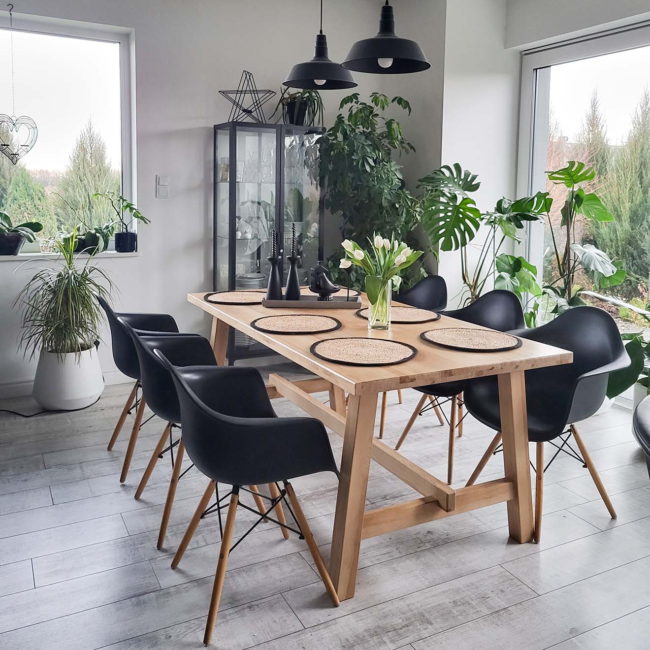 großer Esstisch aus Holz mit schwarzen Stühlen im Essbereich eines modernen Wohnzimmers