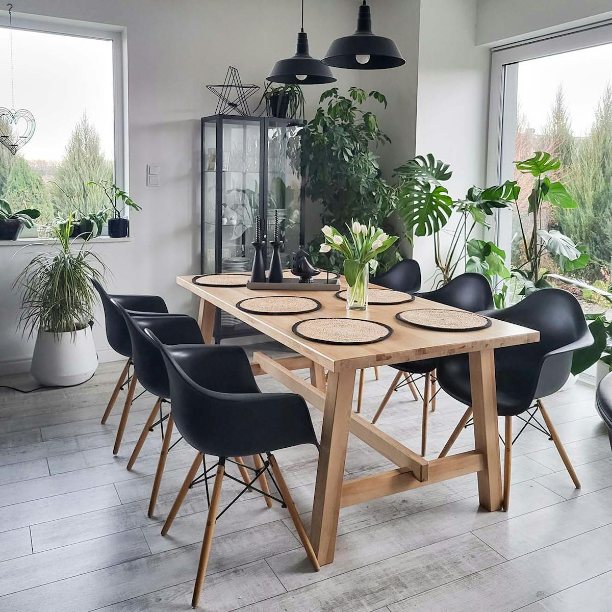 großer Esstisch aus Holz mit schwarzen Stühlen im Essbereich eines modernen Wohnzimmers