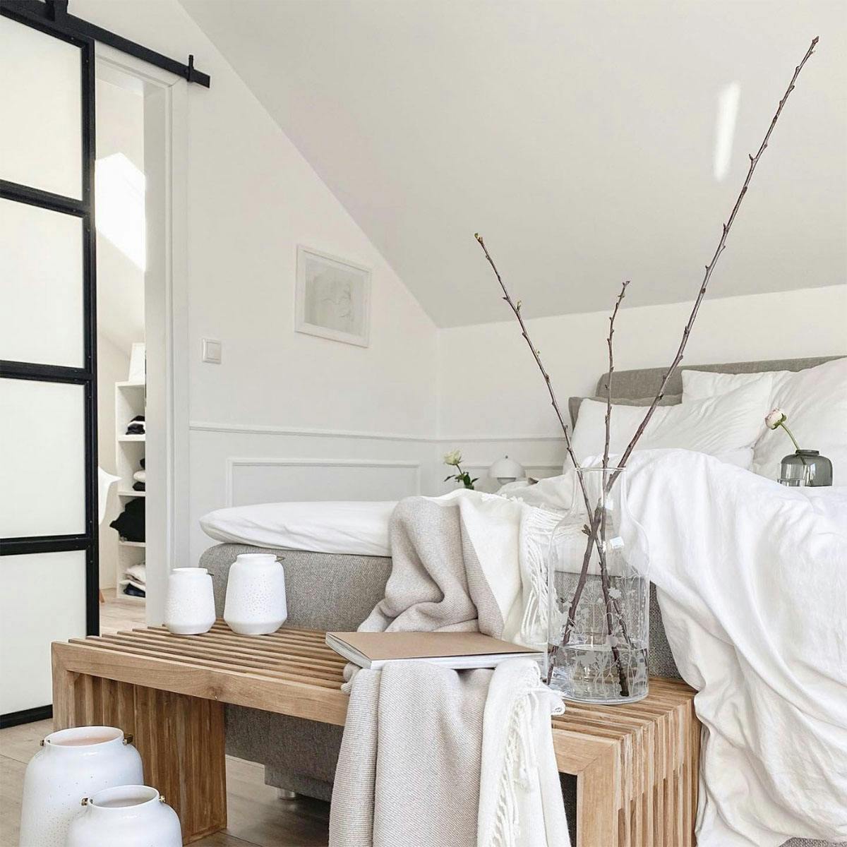 Weiß und Holz in der Gestaltung eines Schlafzimmers im Dachgeschoss im nordischen Stil