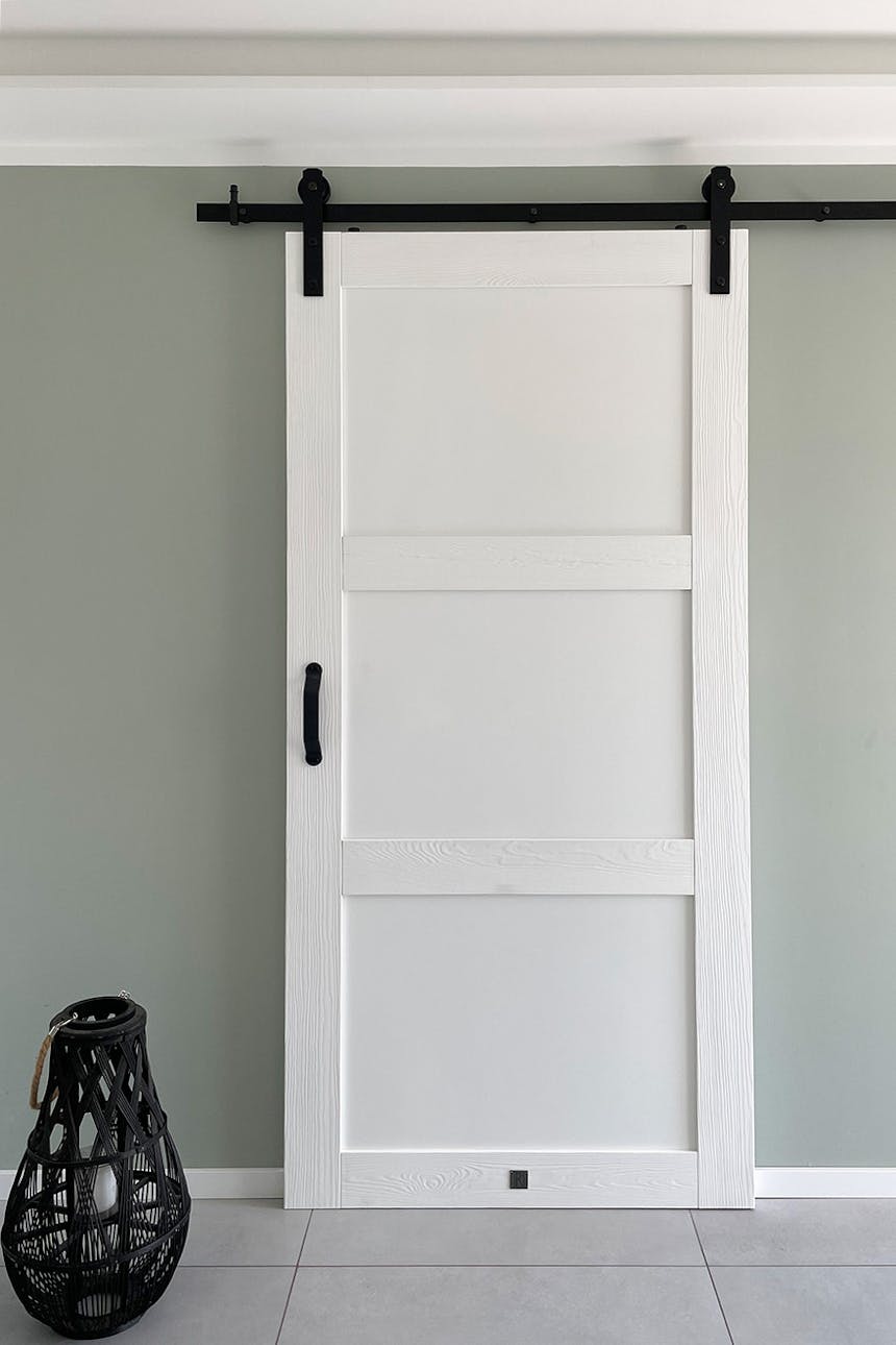 Moderne Schiebetüren, weiße Massivholz-Schiebetüren, weiße Türen auf einem schwarzen Schiebesystem