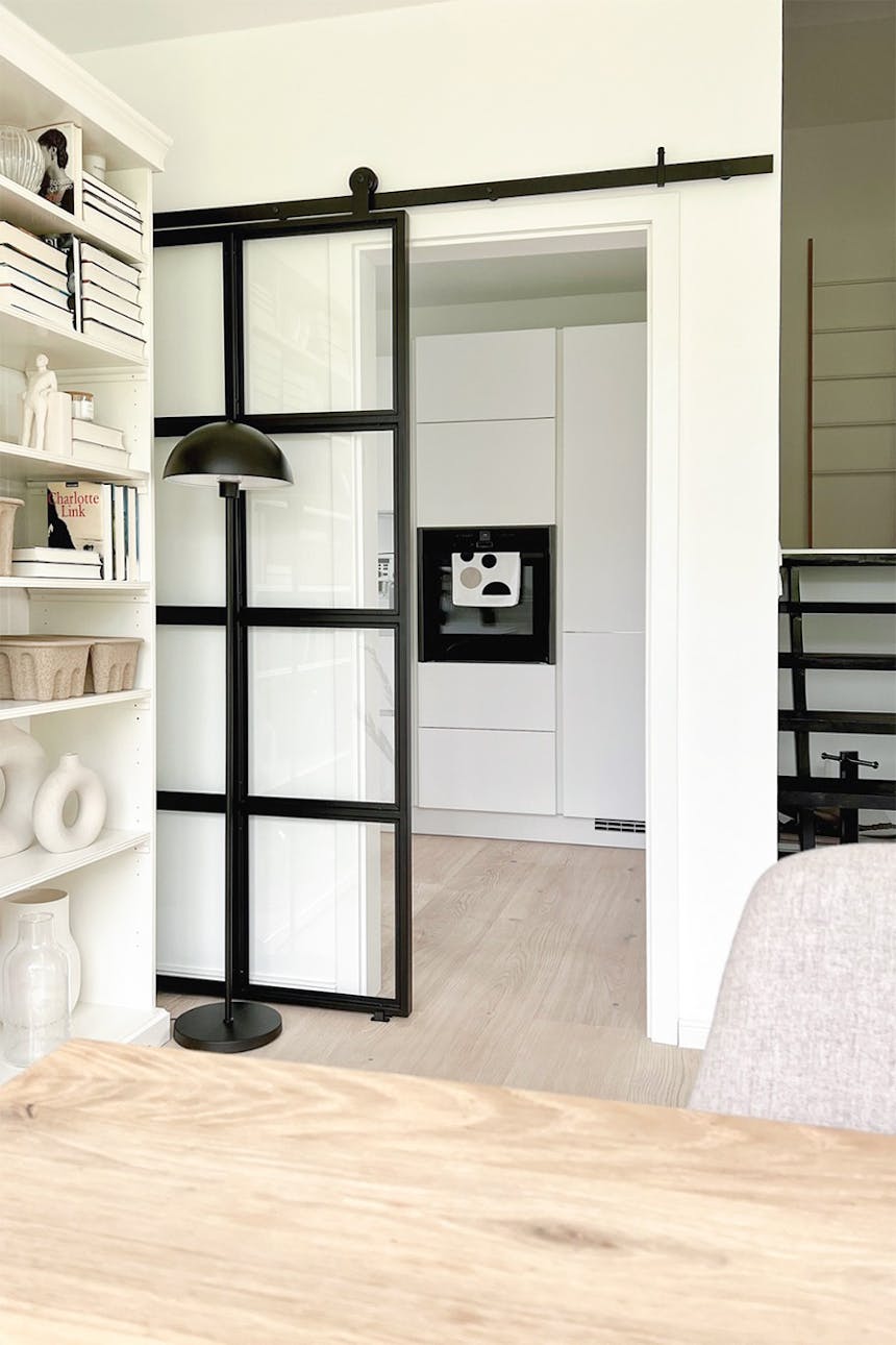 entrance to the kitchen decorated in white colours, sliding doors with glass to the kitchen, industrial doors to the kitchen decorated in a Nordic style