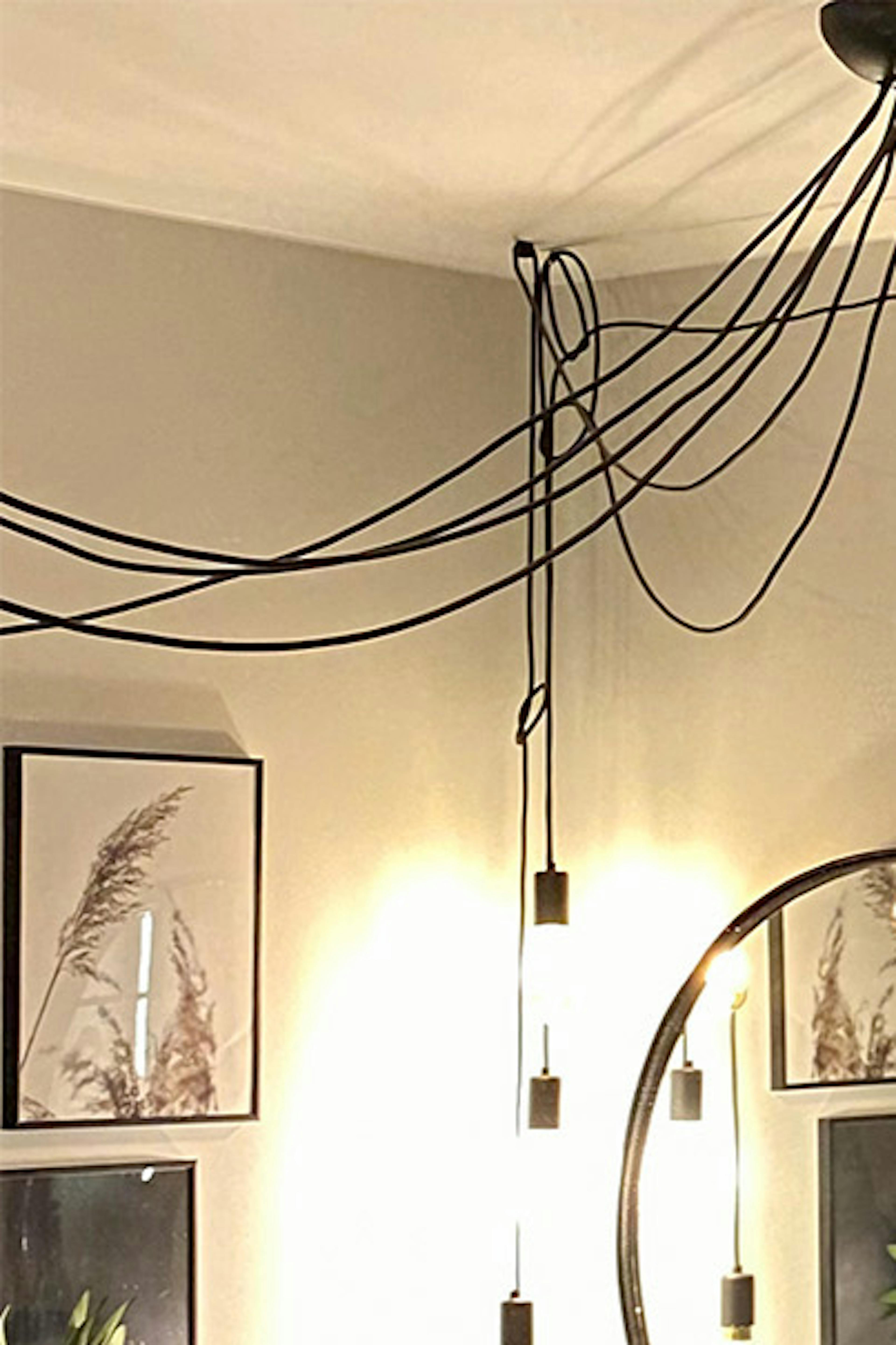 un miroir rond dans un cadre noir au-dessus d'une petite coiffeuse en bois dans le coin d'une chambre de style loft