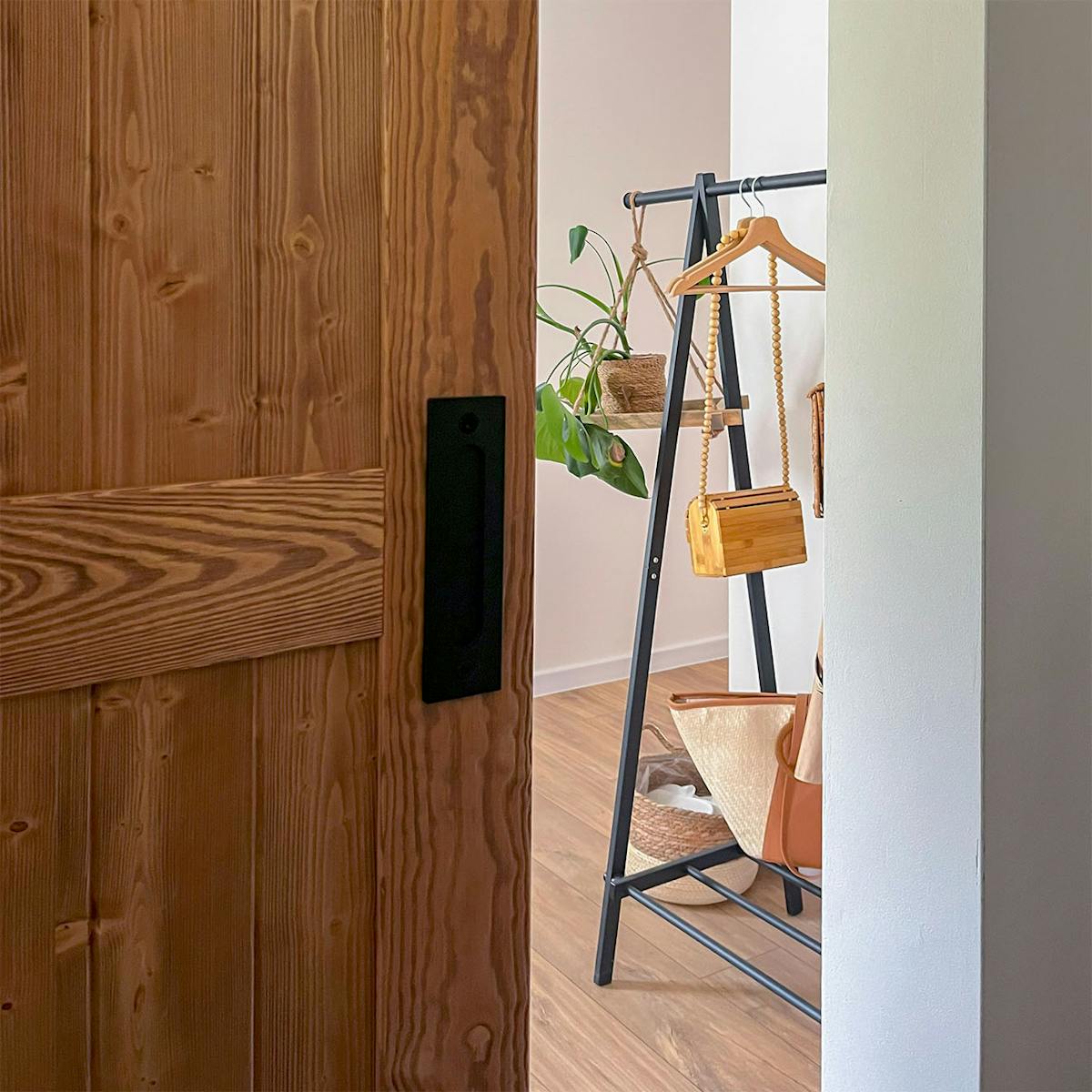 Die Holztür ist offen und gibt den Blick auf ein Fragment des Flurs mit einem Kleiderständer frei