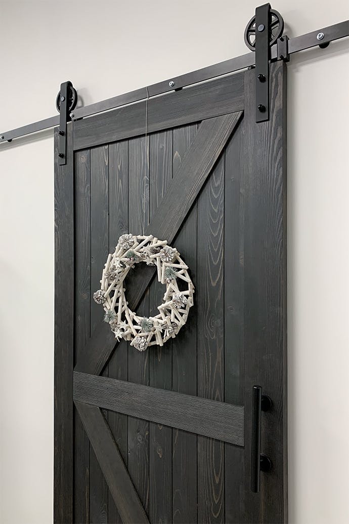 Couronne décorative sur porte coulissante en bois noir