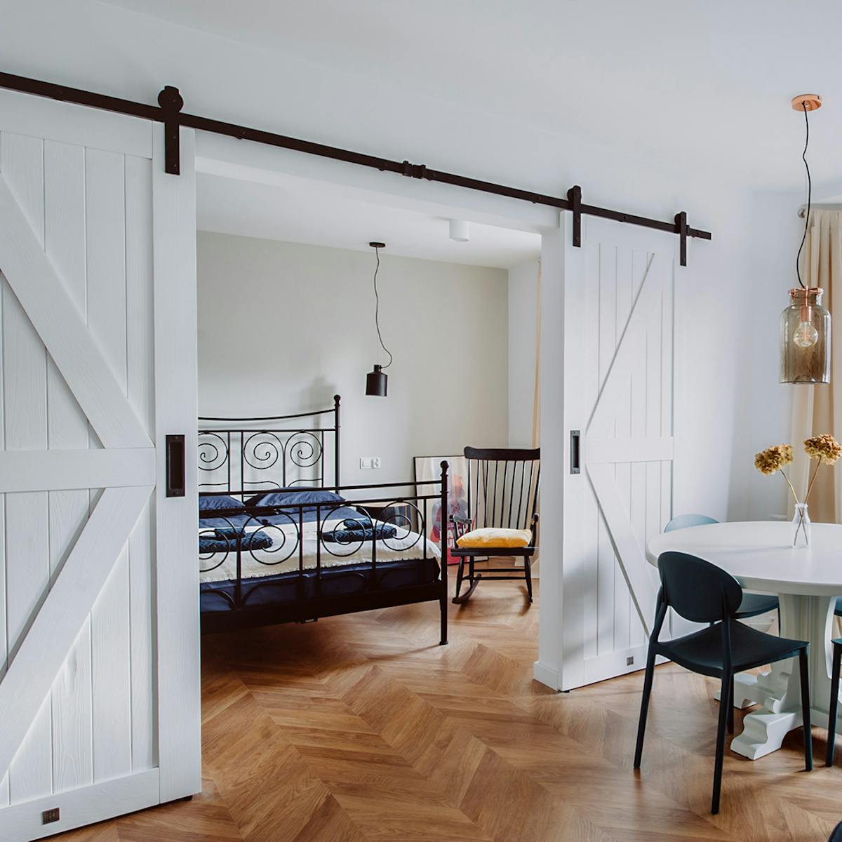 moderner Retro-Stil, Mietwohnungen Wroclaw, Doppelschiebetüren, weiße Schiebetüren, barn door, offener Raum, Doppeltür für Schlafzimmer, Retroschlafzimmer, Schaukelstuhl im Schlafzimmer