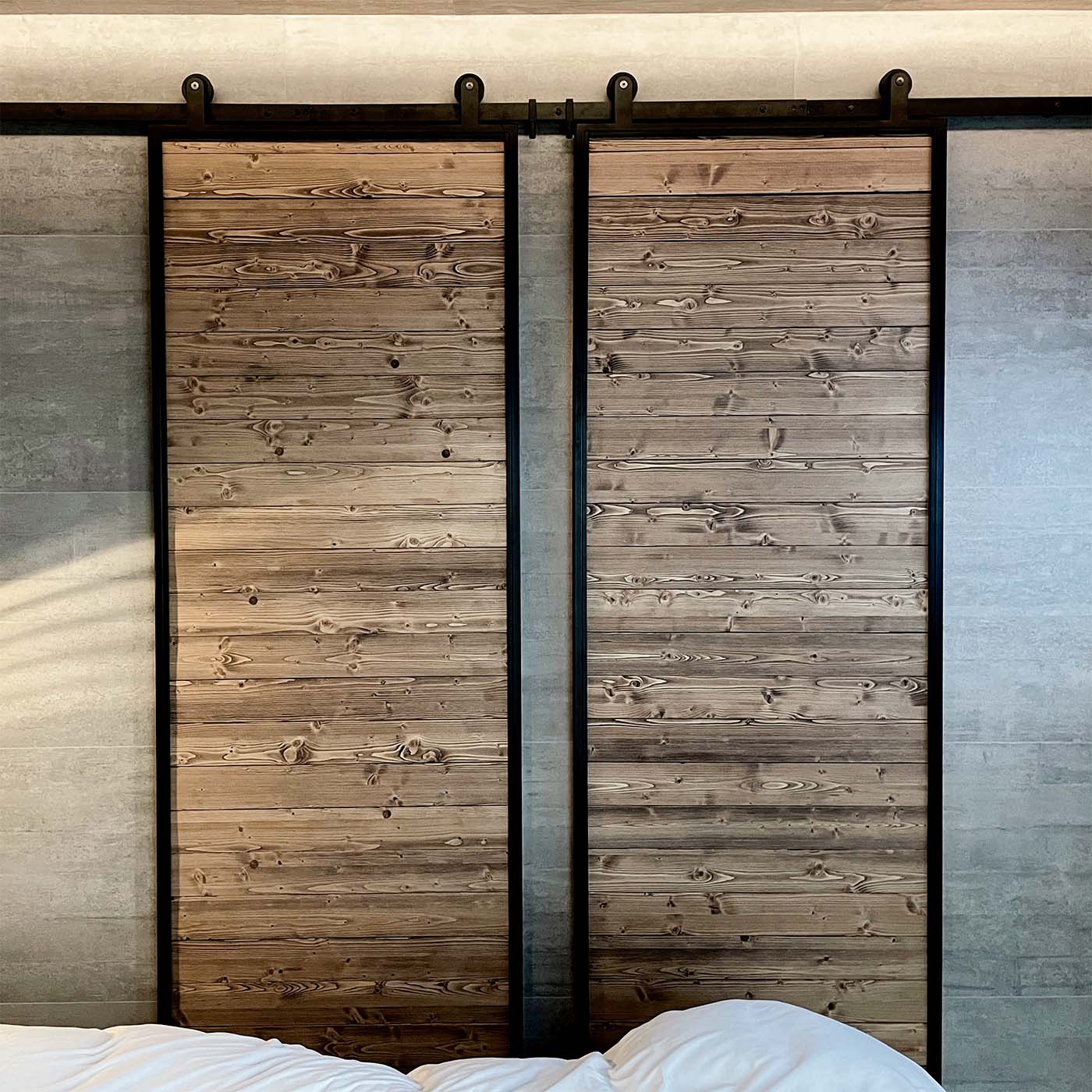 industrielle Schiebetüren aus Massivholz in einem schwarzen Metallrahmen