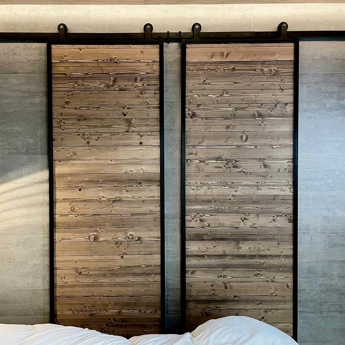 industrielle Schiebetüren aus Massivholz in einem schwarzen Metallrahmen