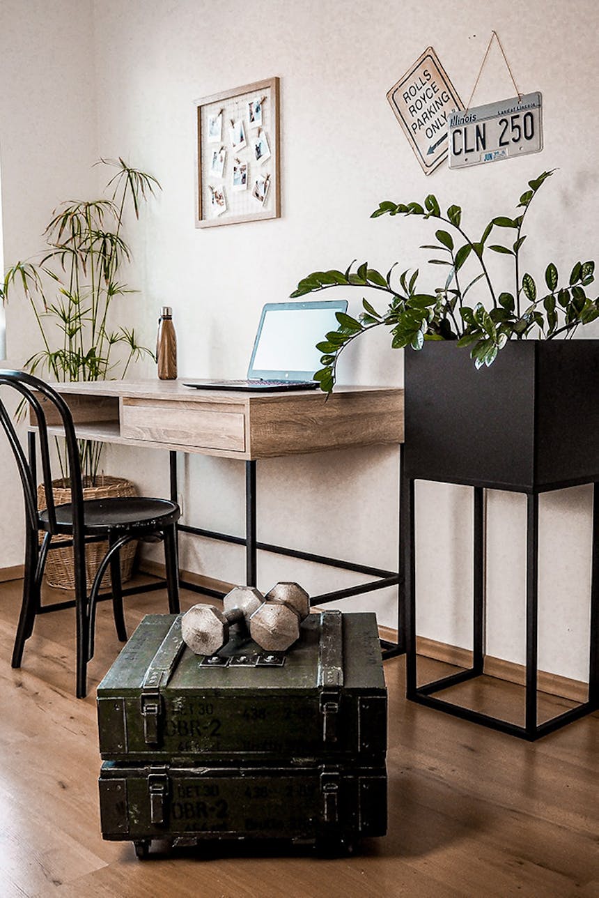 stare skrzynie wojskowe w pokoju z dużym biurkiem wykonanym z drewna i metalu