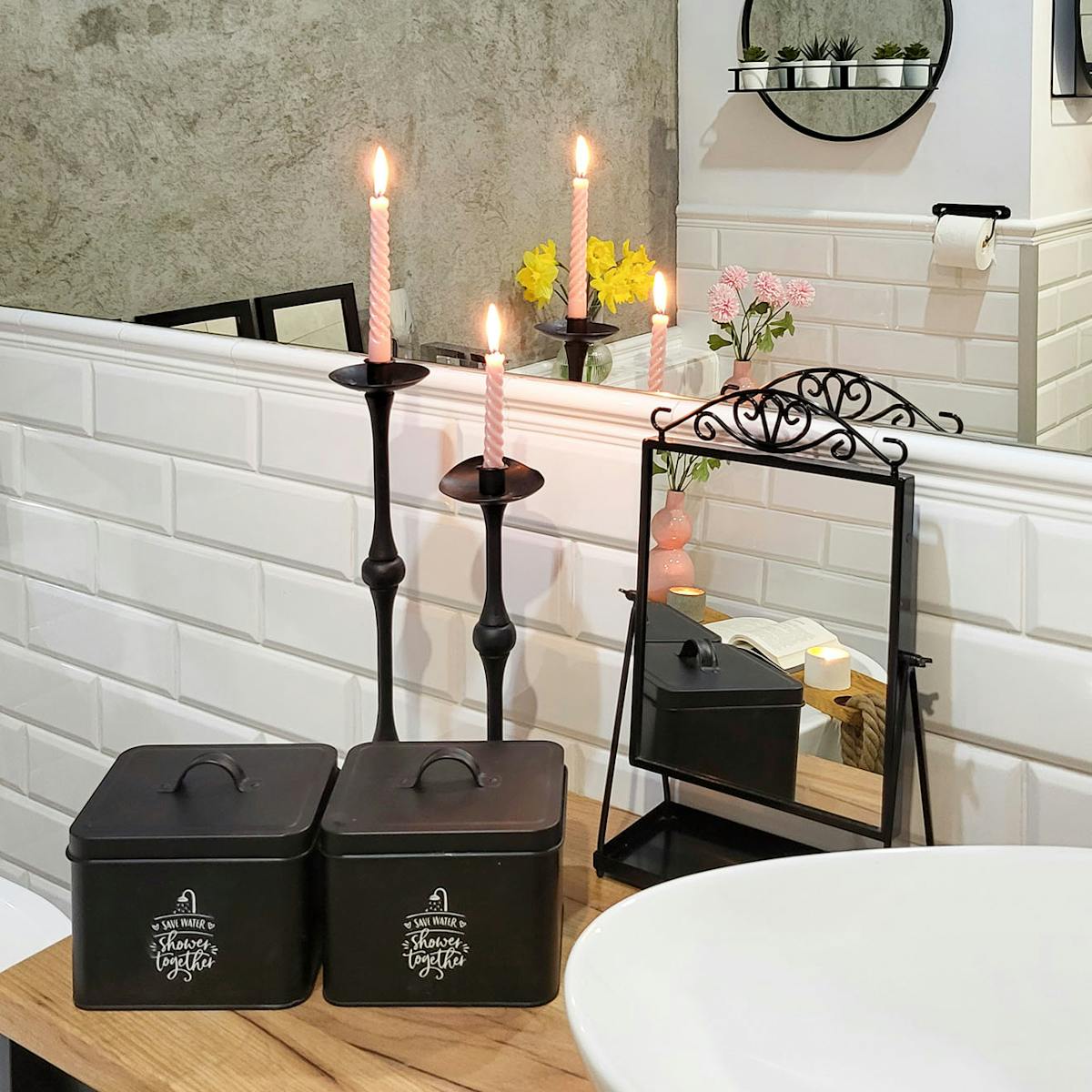 czarne pojemniki, lustro i ozdobne świeczniki na blacie w łazience