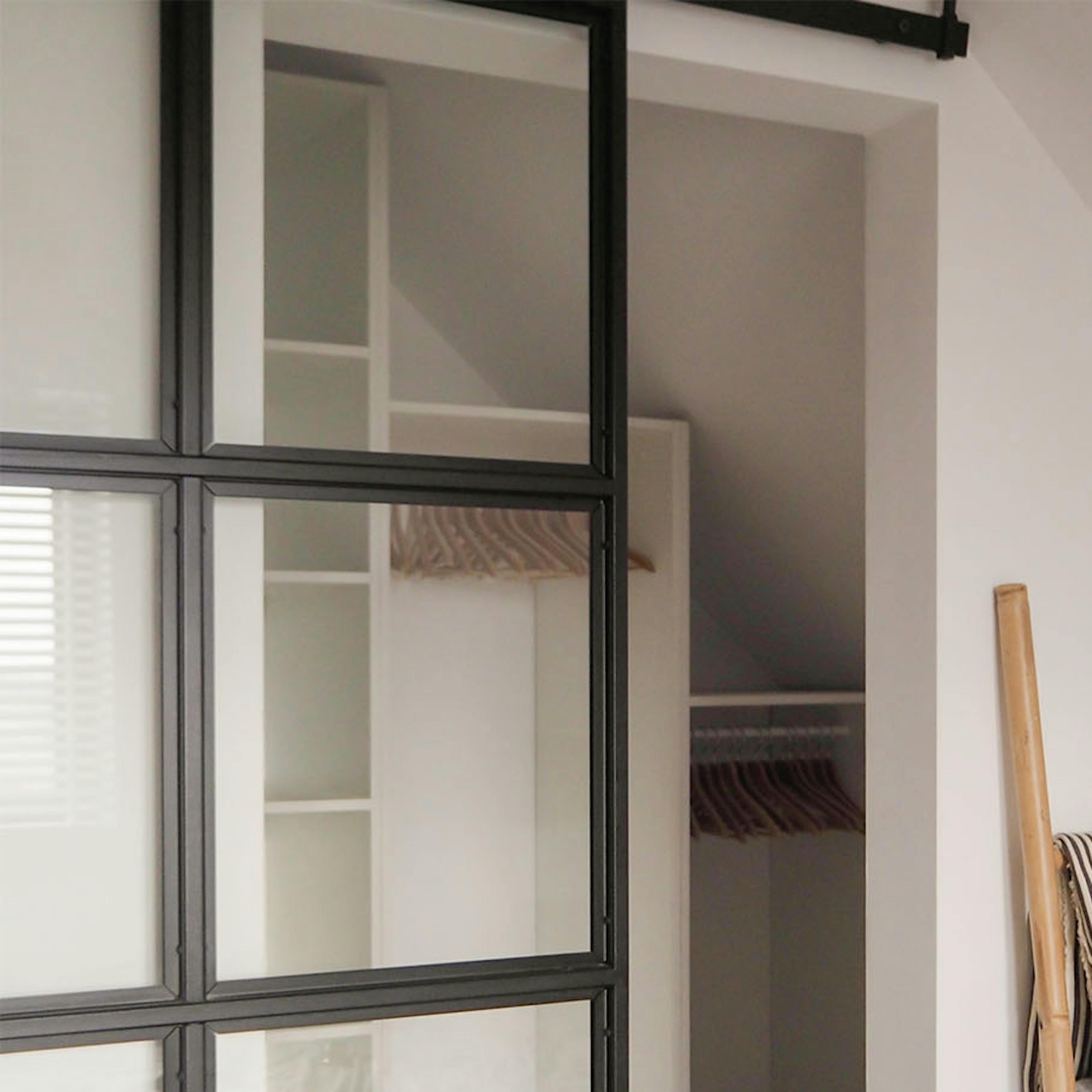 porte style loft avec du verre dans un cadre en métal fermant la dressing dans une petite chambre mansardée