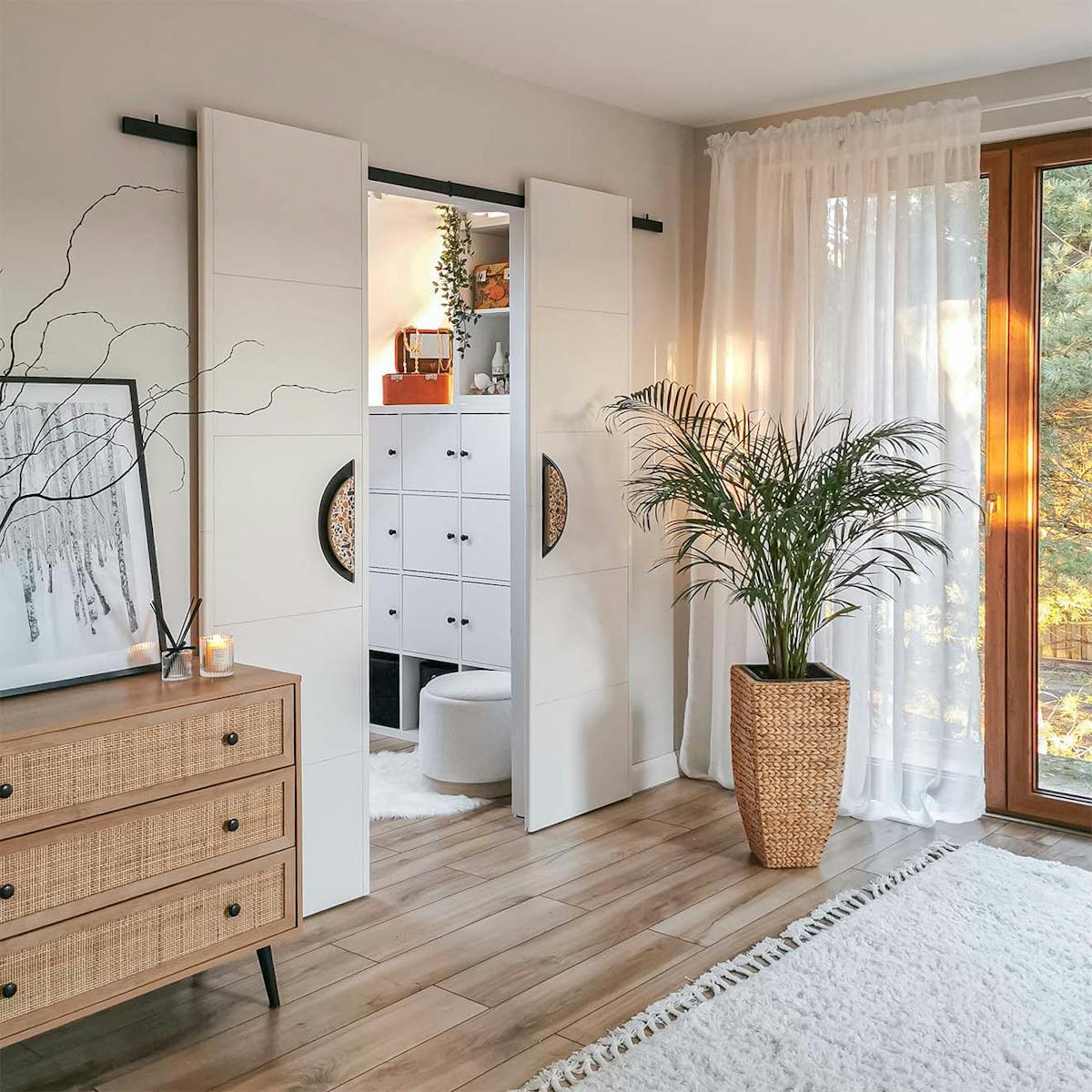 Schlafzimmer mit begehbarem Kleiderschrank hinter weißen Doppelschiebetüren