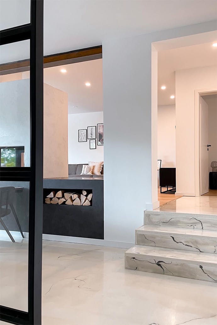 Un intérieur moderne avec des murs blancs, un sol clair et des accessoires noirs