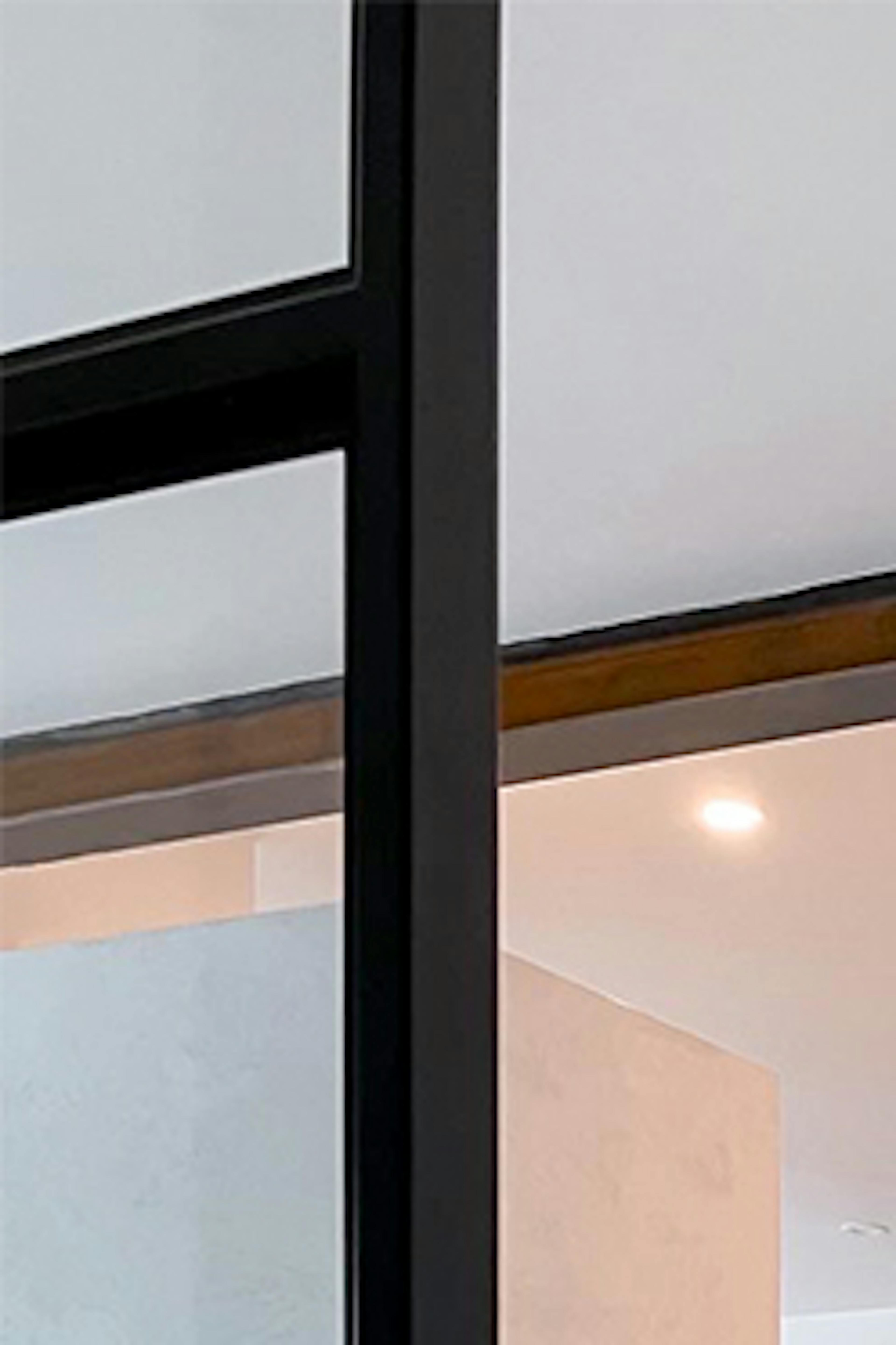 Un intérieur moderne avec des murs blancs, un sol clair et des accessoires noirs