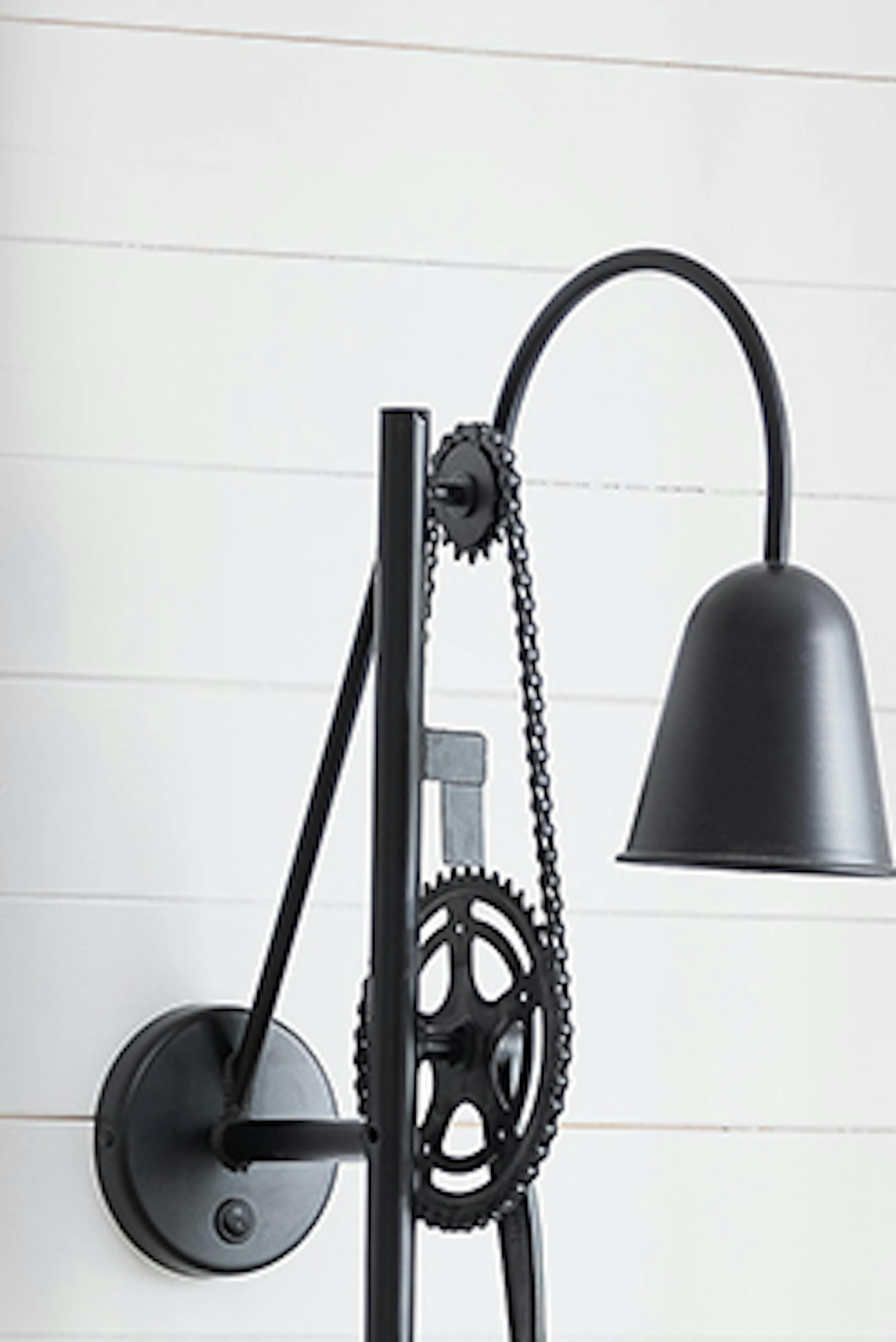 Une applique murale loft noire au-dessus d'un canapé lumineux
