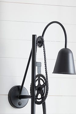 Une applique murale loft noire au-dessus d'un canapé lumineux