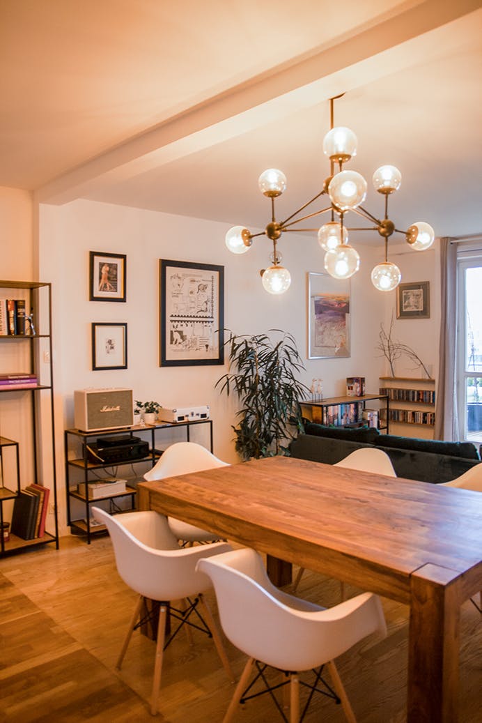 lustre décoratif au-dessus d'une table en bois dans un salon éclectique