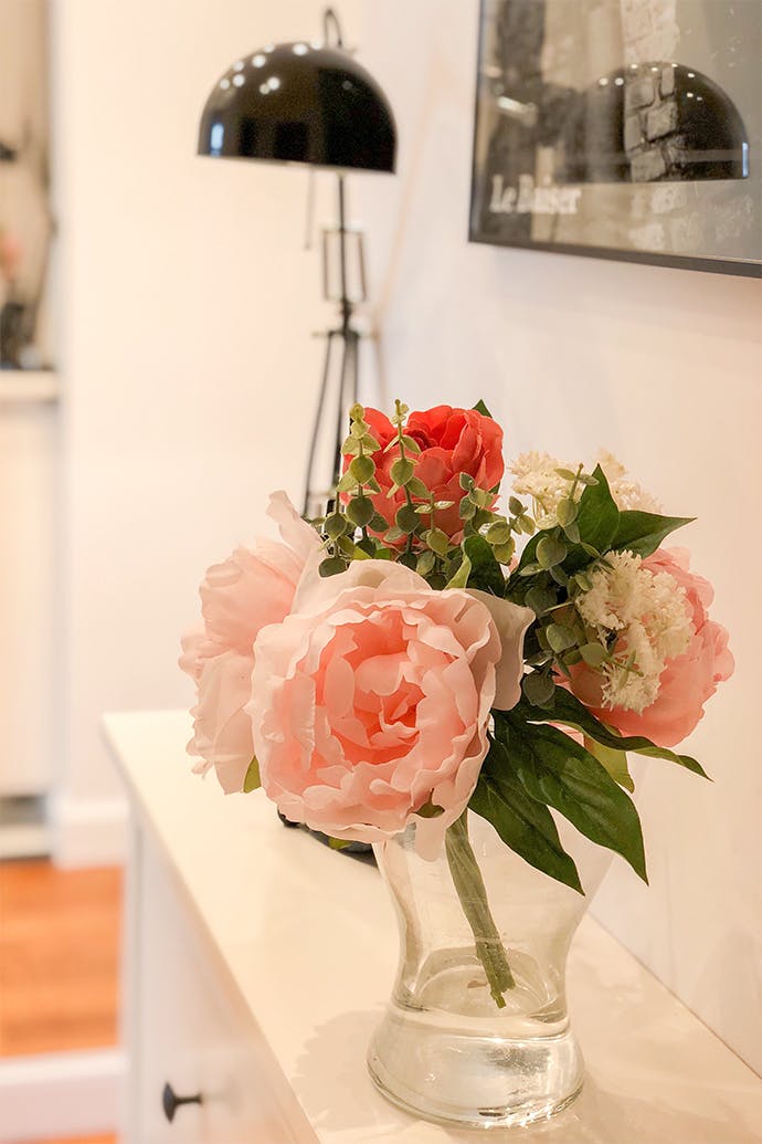 fleurs dans un vase sur une commode blanche