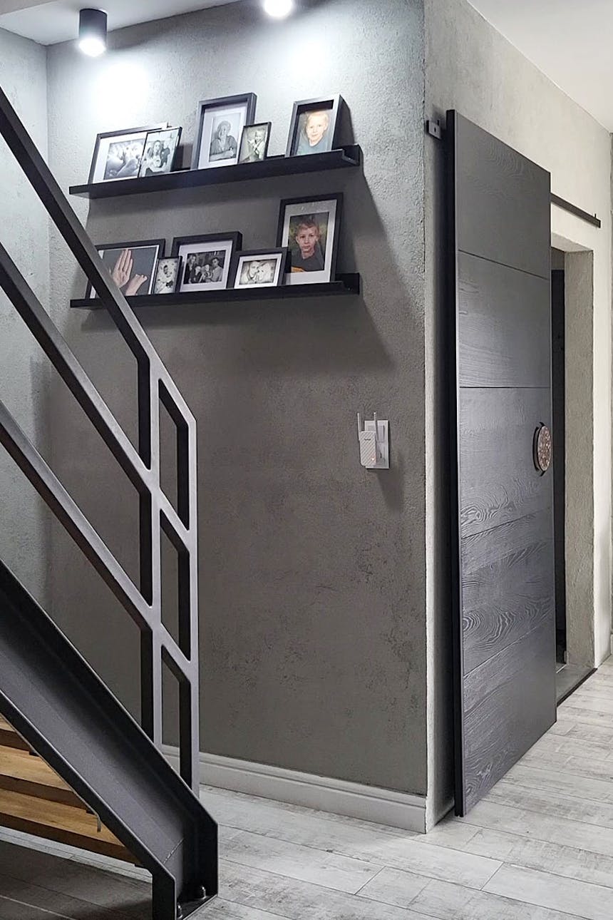 Fotogalerie in schwarzen Rahmen an einer grauen Betonwand