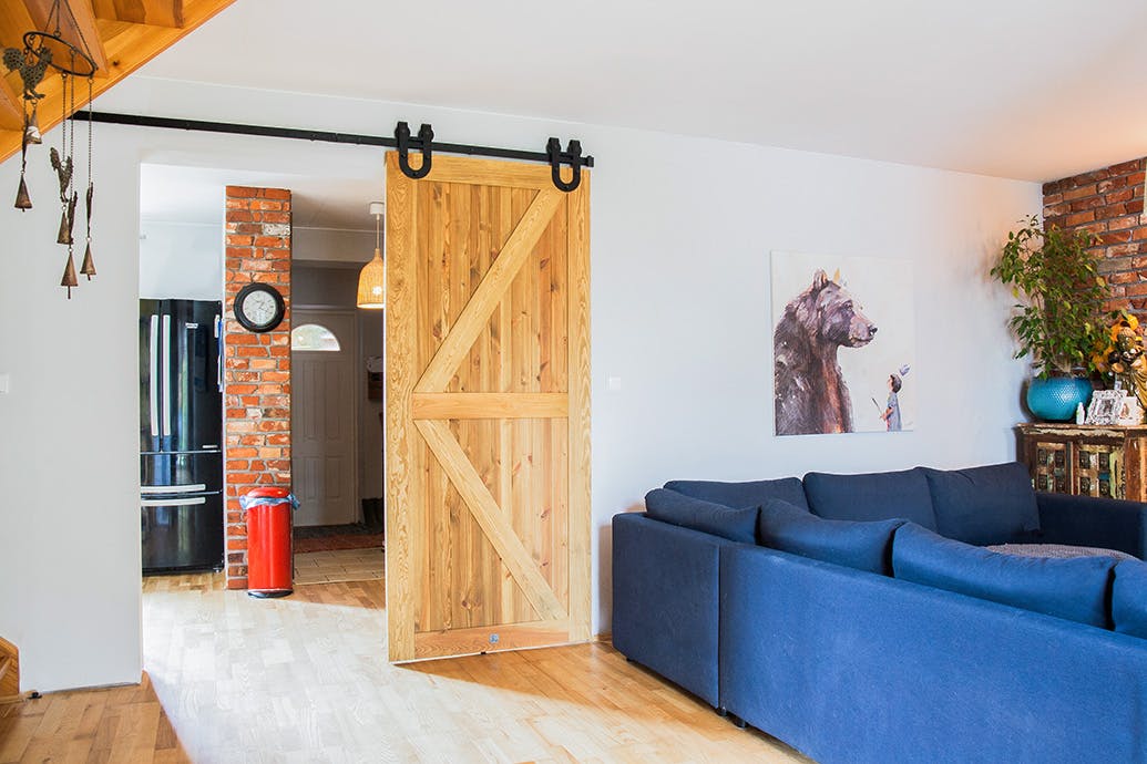 grand salon ouvert avec canapé bleu et portes coulissantes en bois