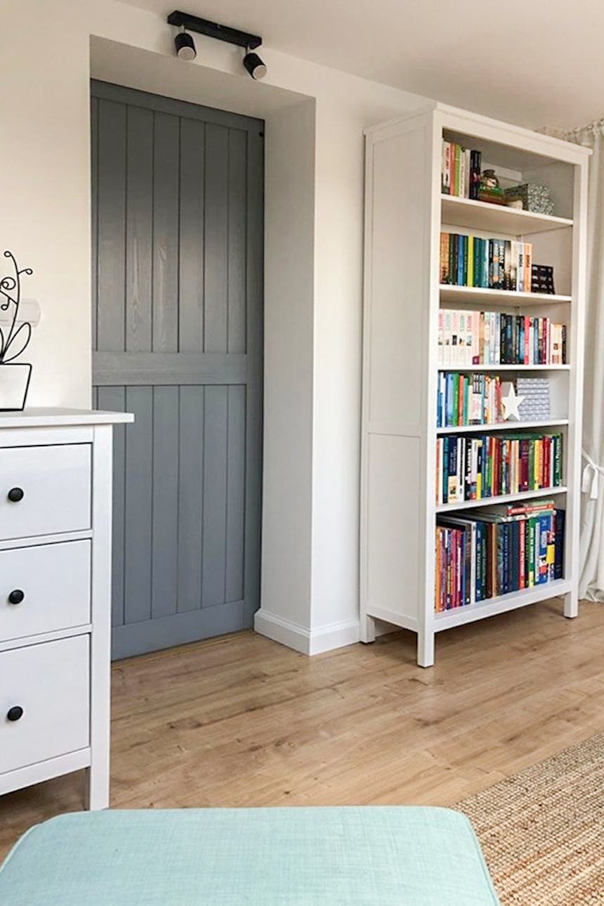 portes coulissantes grises et une bibliothèque blanche dans la chambre mansardée