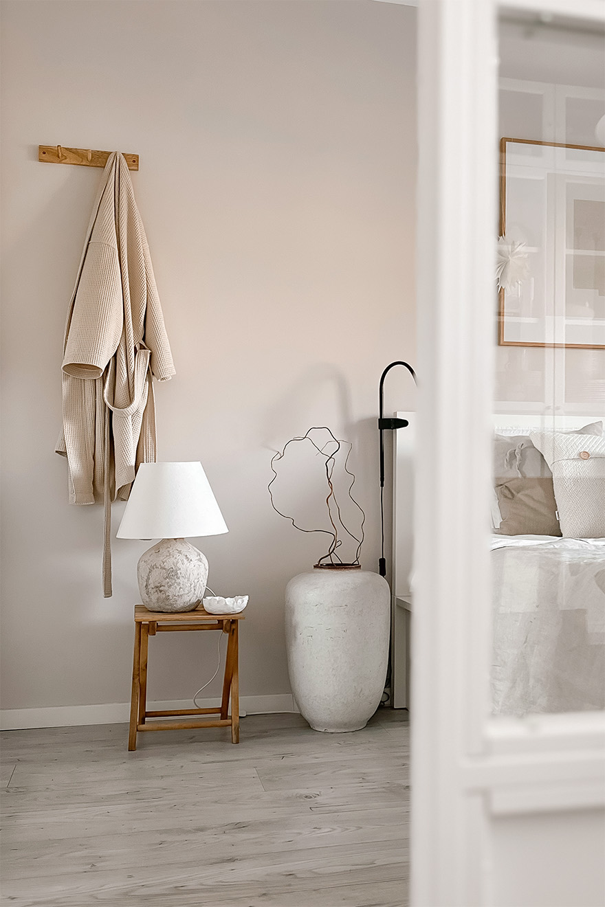 ein Kleiderbügel und ein Holztisch mit Nachttischlampe