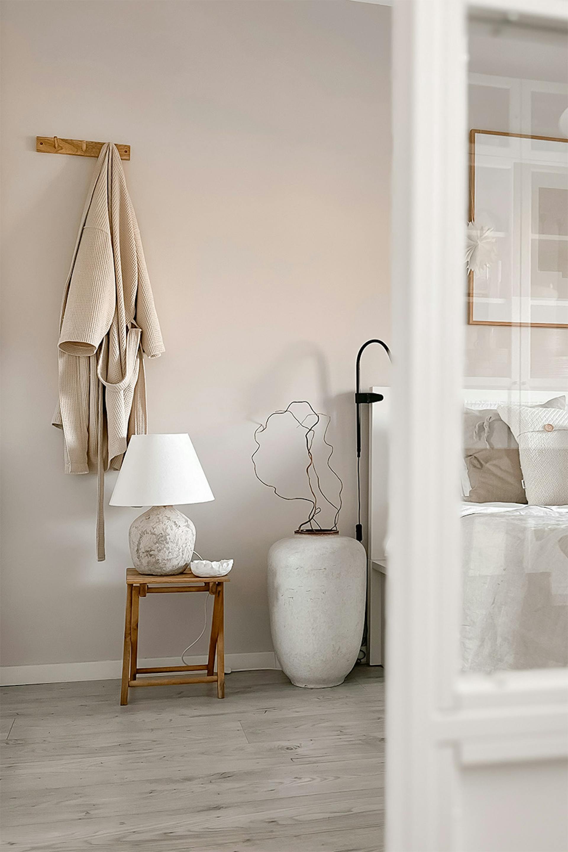 ein Kleiderbügel und ein Holztisch mit Nachttischlampe