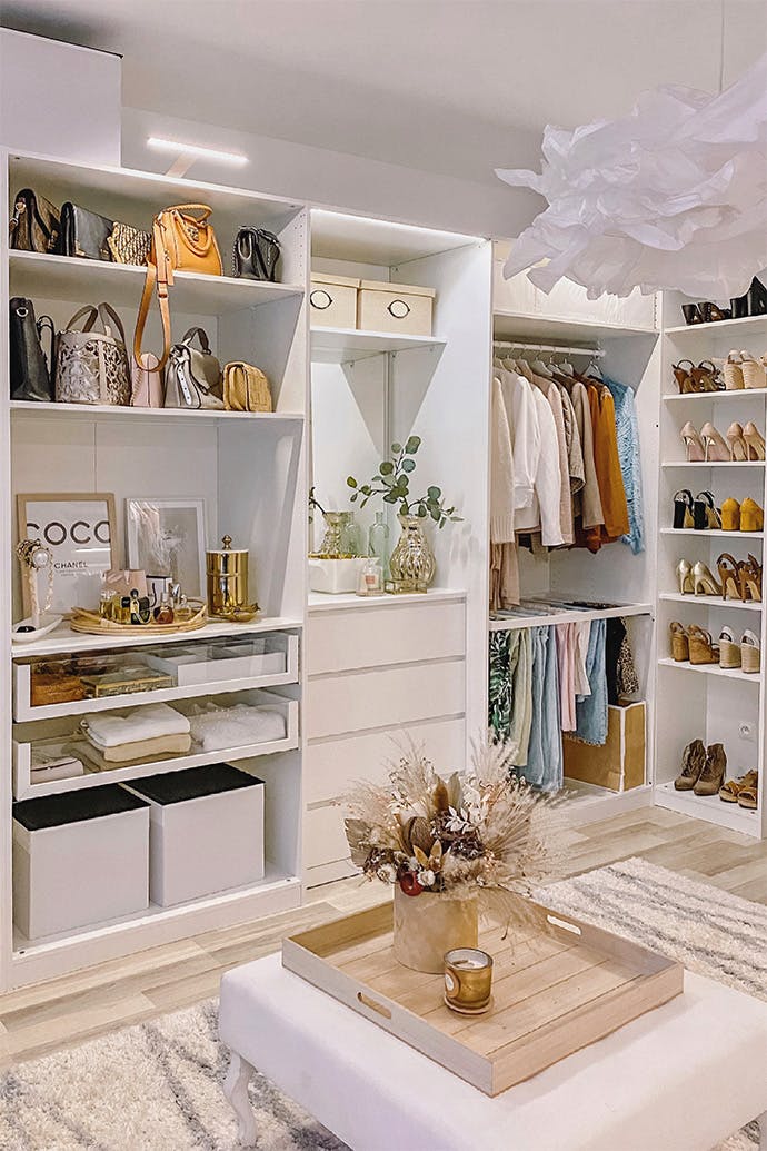 system of white shelves in the dressing room, large bright dressing room, white shelves, white pouf in the walk-in closet