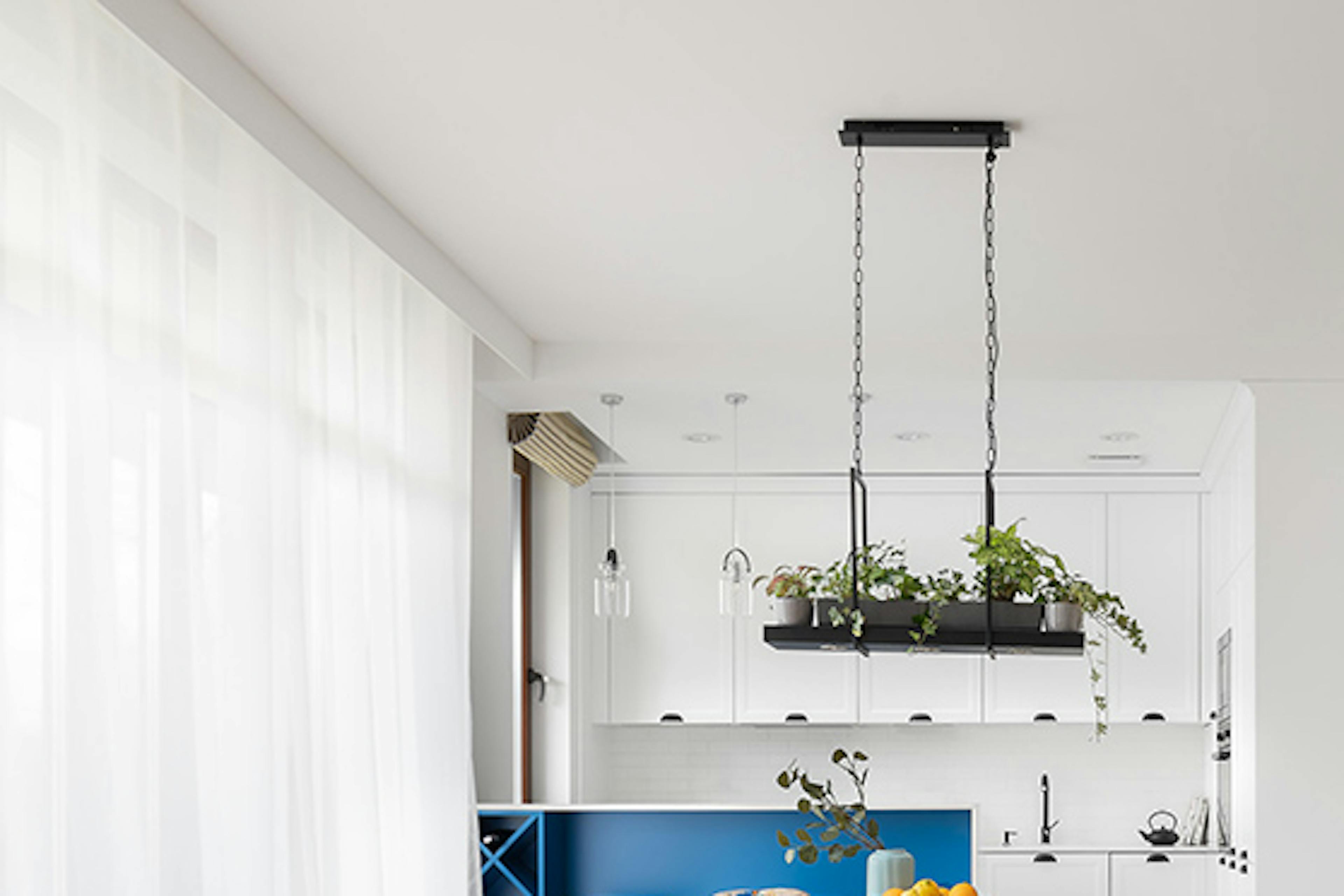 Un salon lumineux combiné à une salle à manger et une cuisine, décoré en blanc et bois dans le style côtier californien