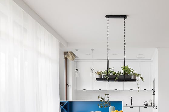 Un salon lumineux combiné à une salle à manger et une cuisine, décoré en blanc et bois dans le style côtier californien