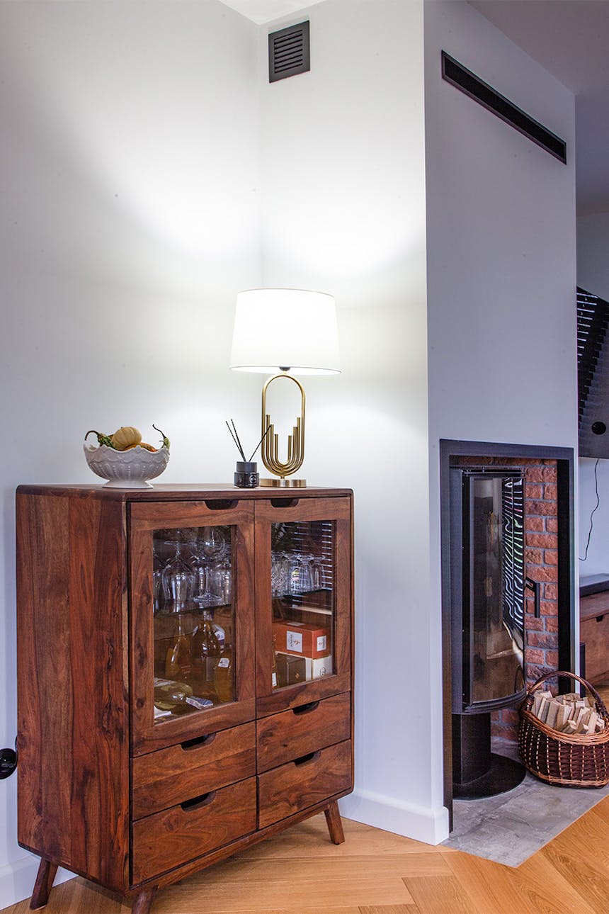 drewniana witryna z szufladami i przeszklonymi frontami na tle białej ściany