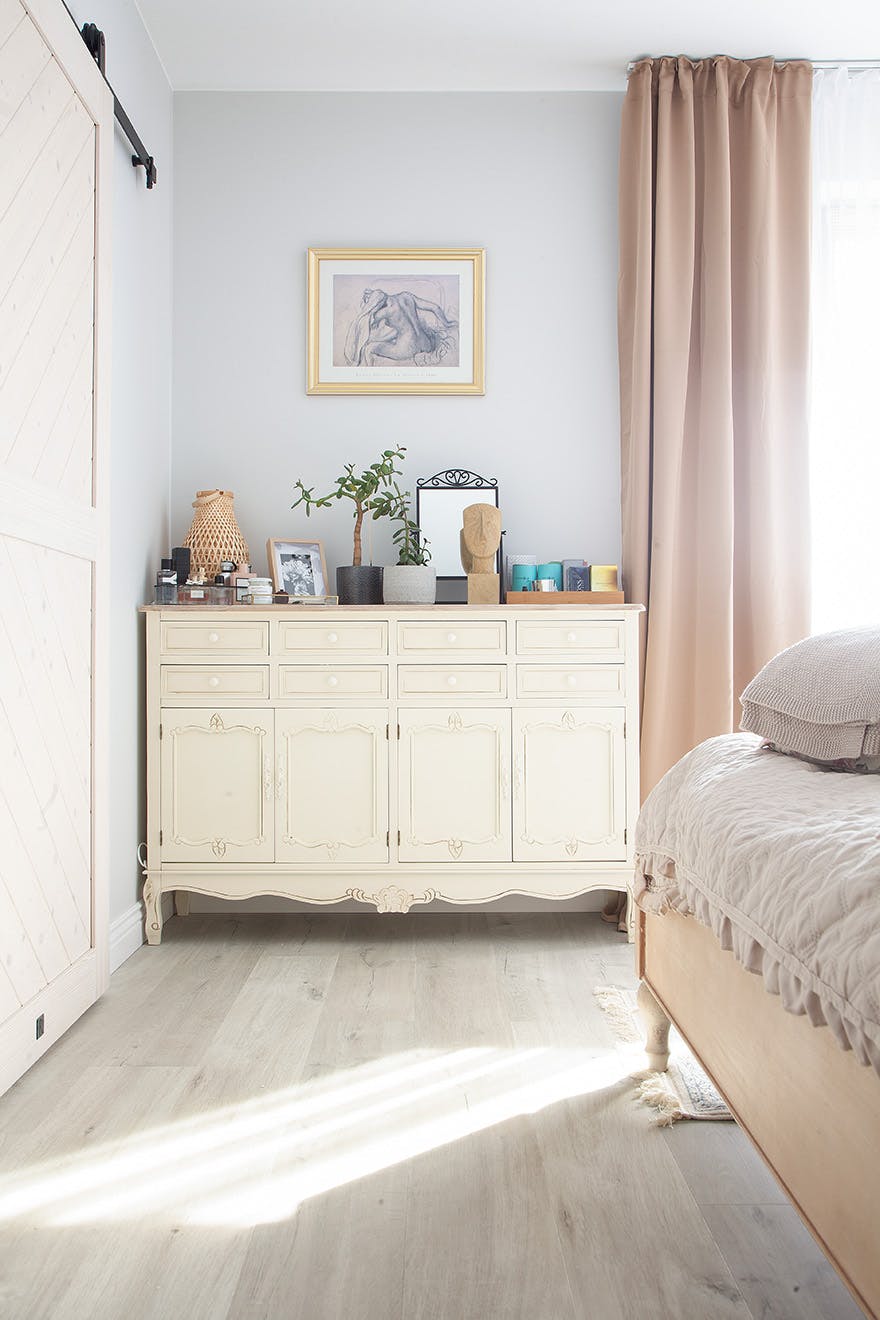 cream chest of drawers with decorative stucco in a bright bedroom