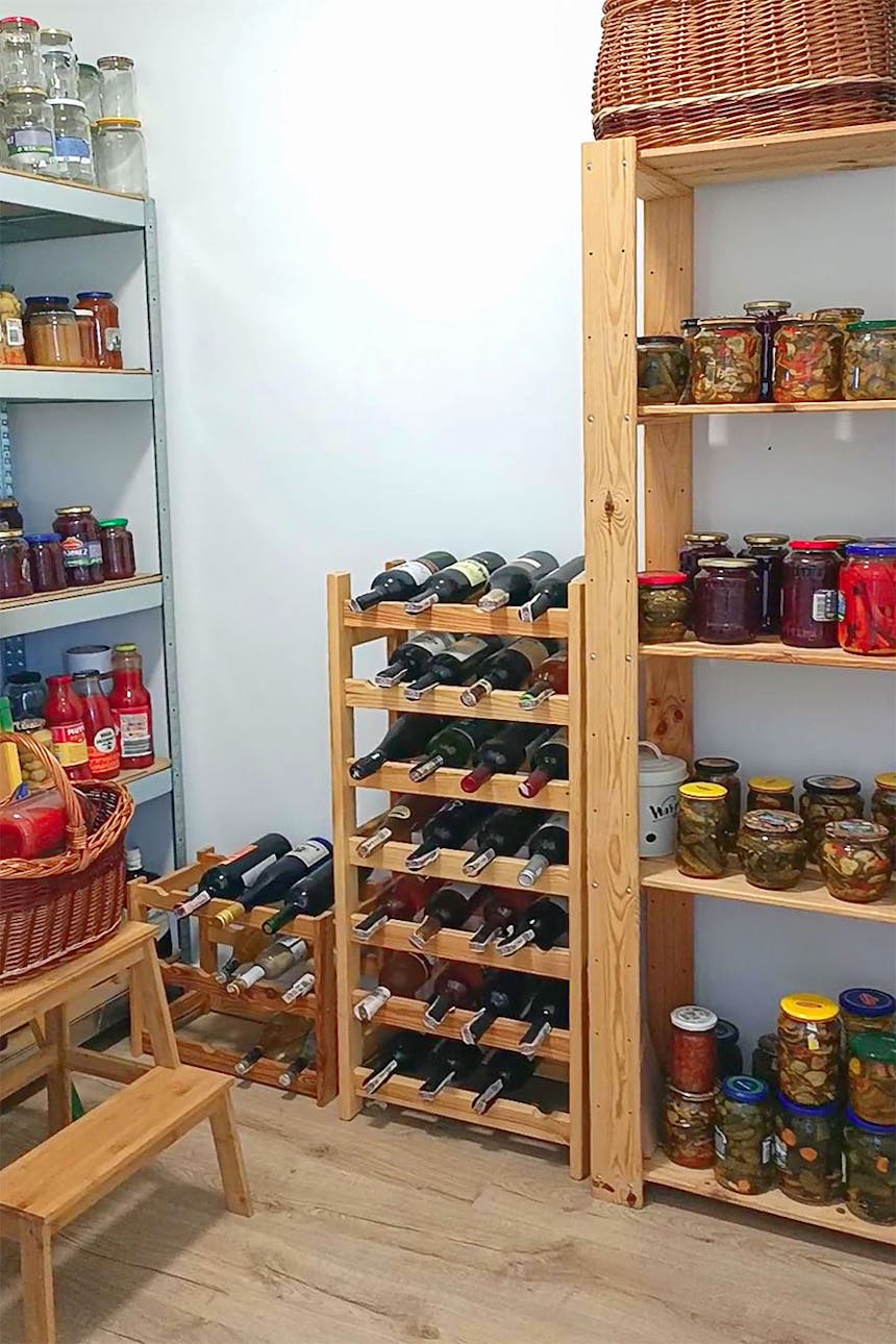 Holzregale gefüllt mit Konserven in einer kleinen Speisekammer