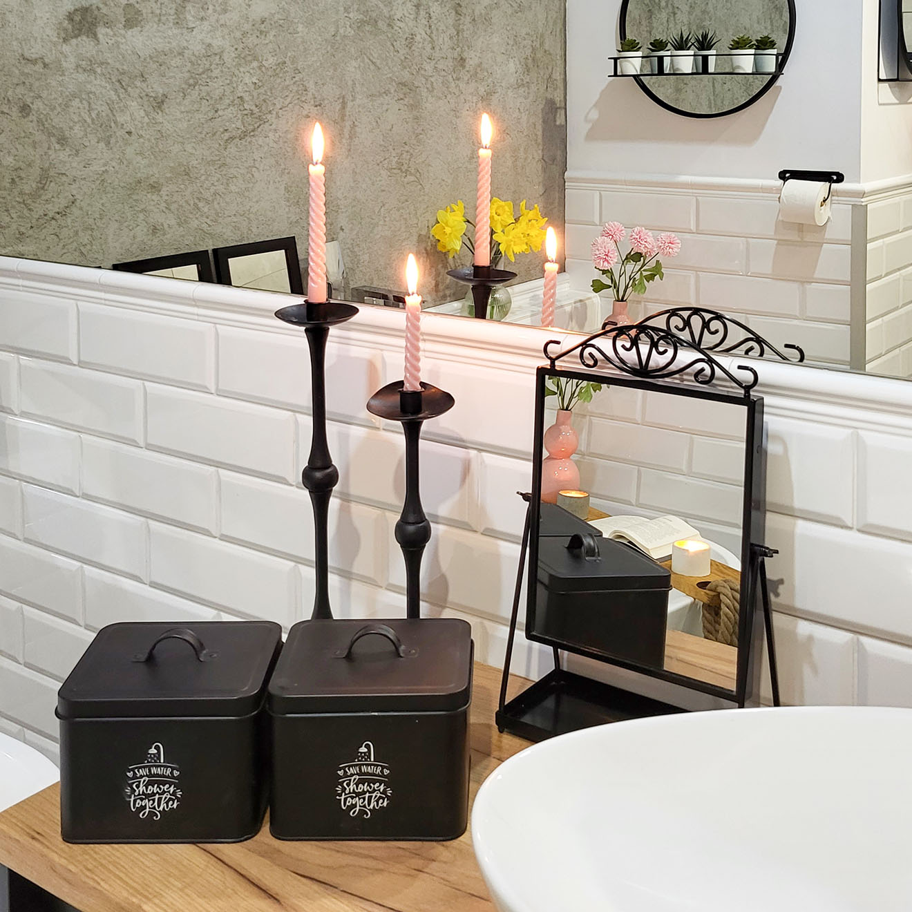 schwarze Behälter, Spiegel und dekorative Kerzenständer auf der Badezimmertheke