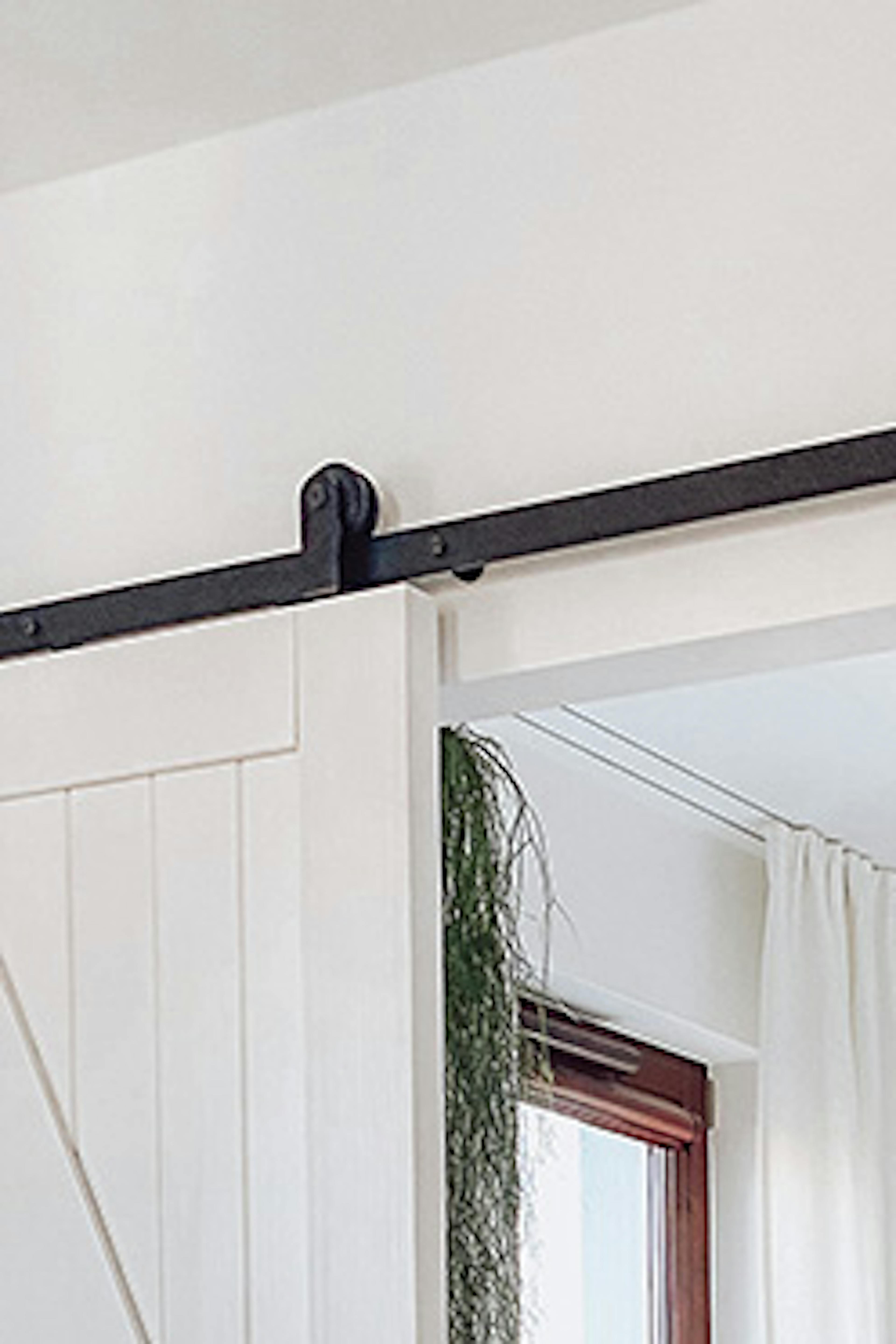 porte coulissante ouverte montrant un fragment d'une chambre décorée en blanc