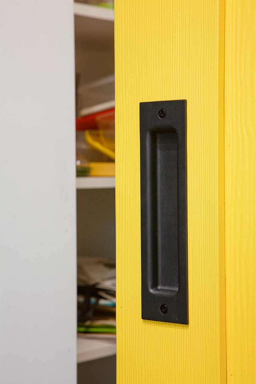 schwarzer türgriff an gelber holztür