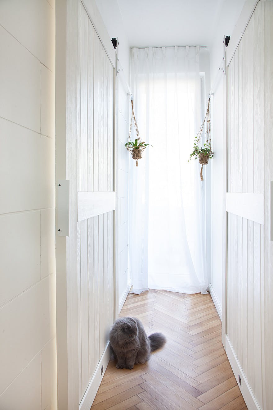 narrow corridor with white sliding doors
