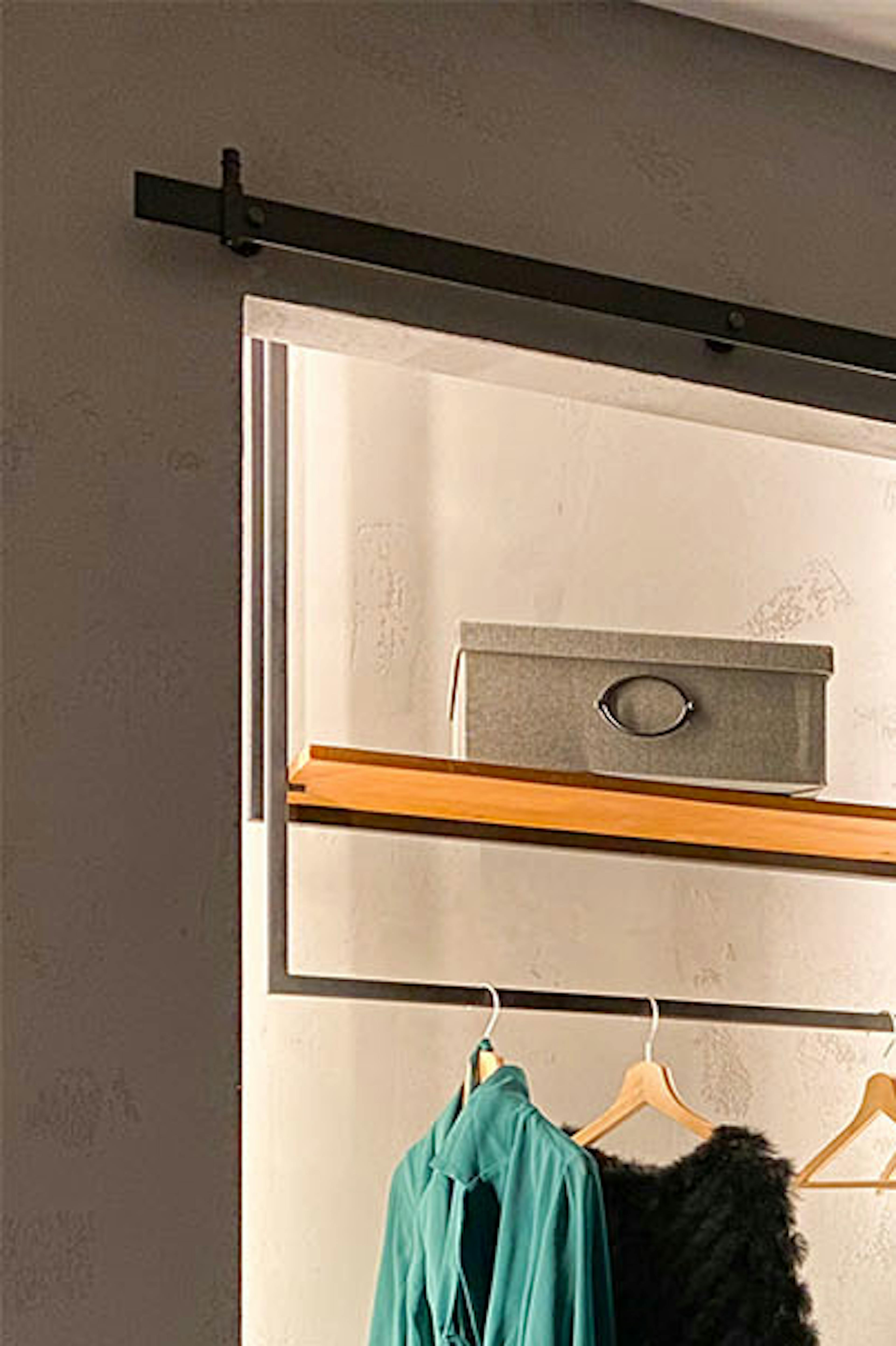 portes coulissantes ouvertes montrant l'intérieur d'une petite armoire en alcôve dans une chambre de style loft