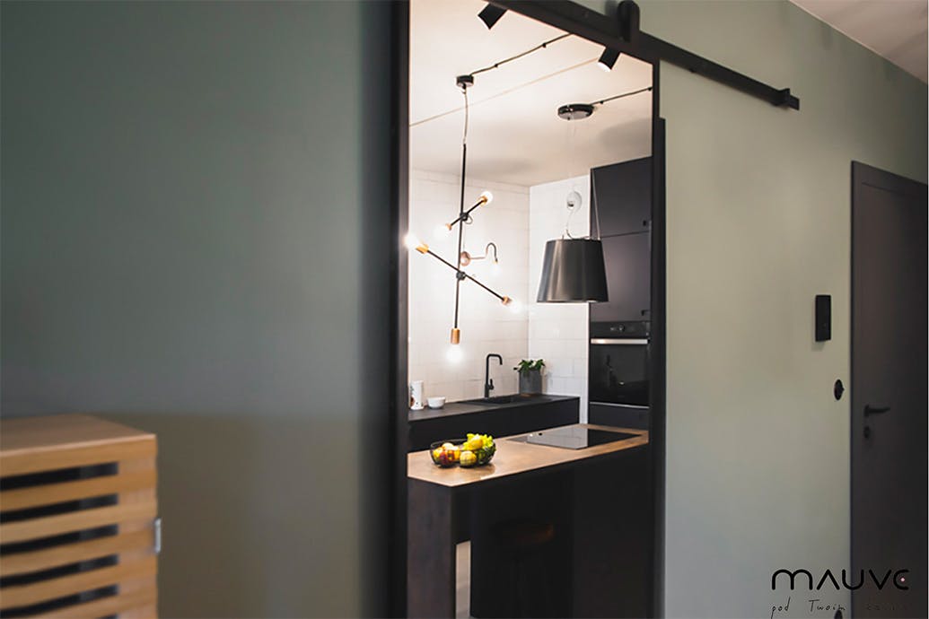 Porte coulissante industrielle avec miroir dans un petit appartement