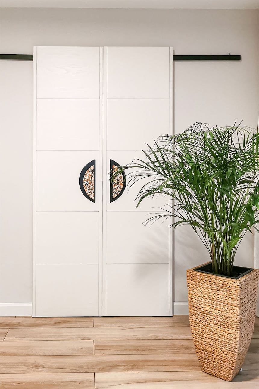 minimalistyczne podwójne drzwi przesuwne w kolorze białym z klamkami w stylu lastryko