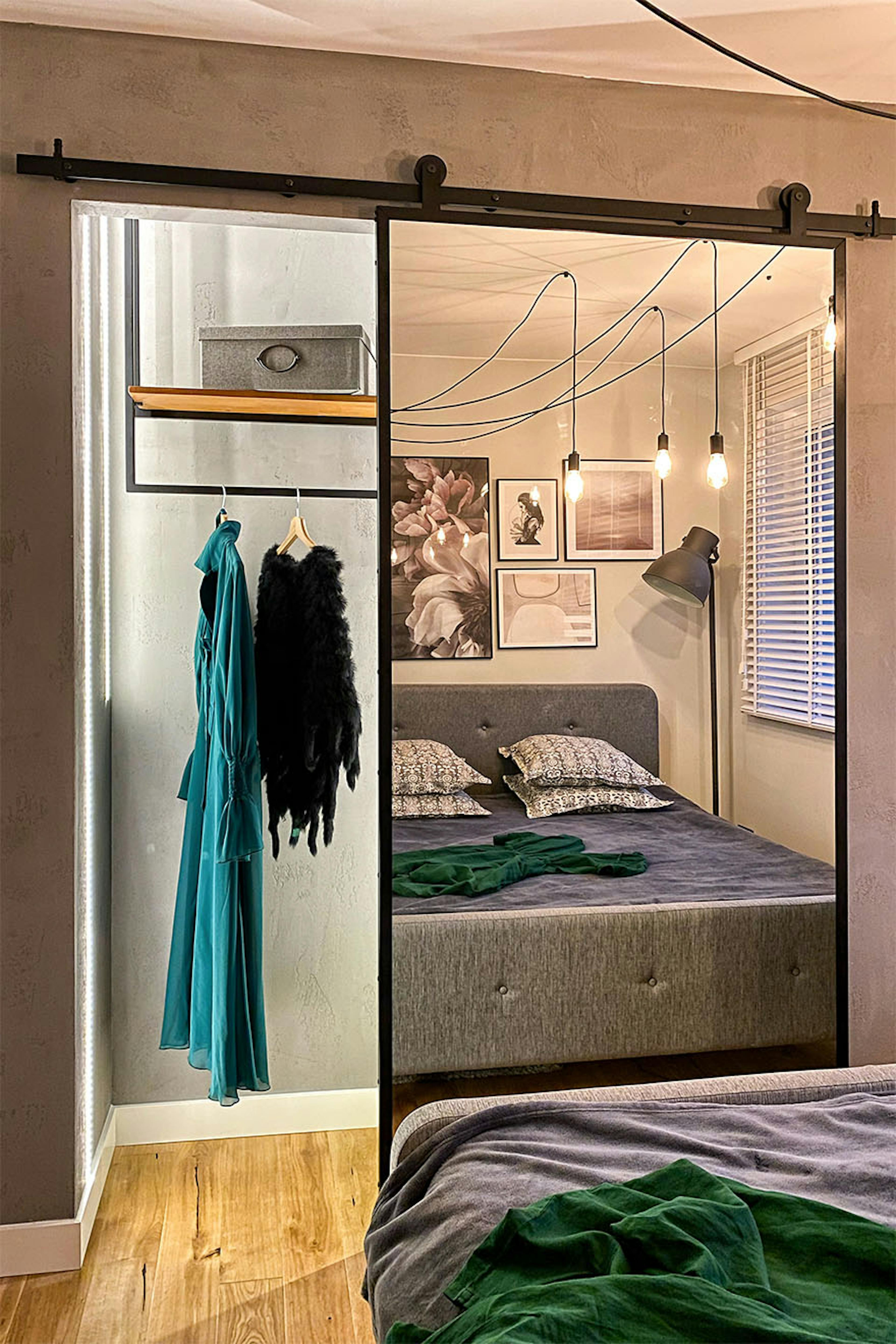 porte coulissante avec un miroir dans un cadre en métal sur un mur gris dans une chambre de style loft aux couleurs grises