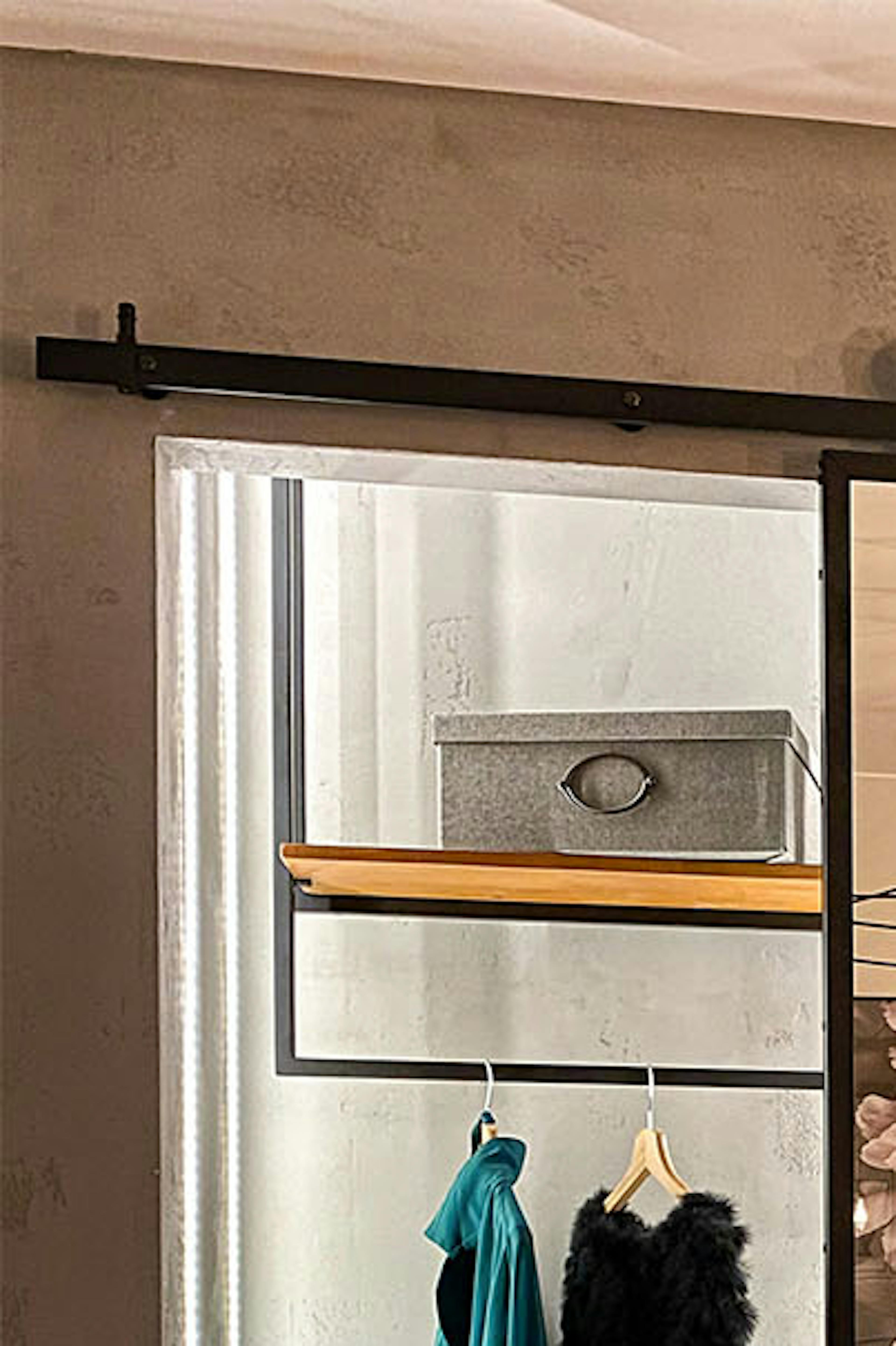 portes coulissantes ouvertes montrant une petite armoire en alcôve dans la chambre décorée en gris